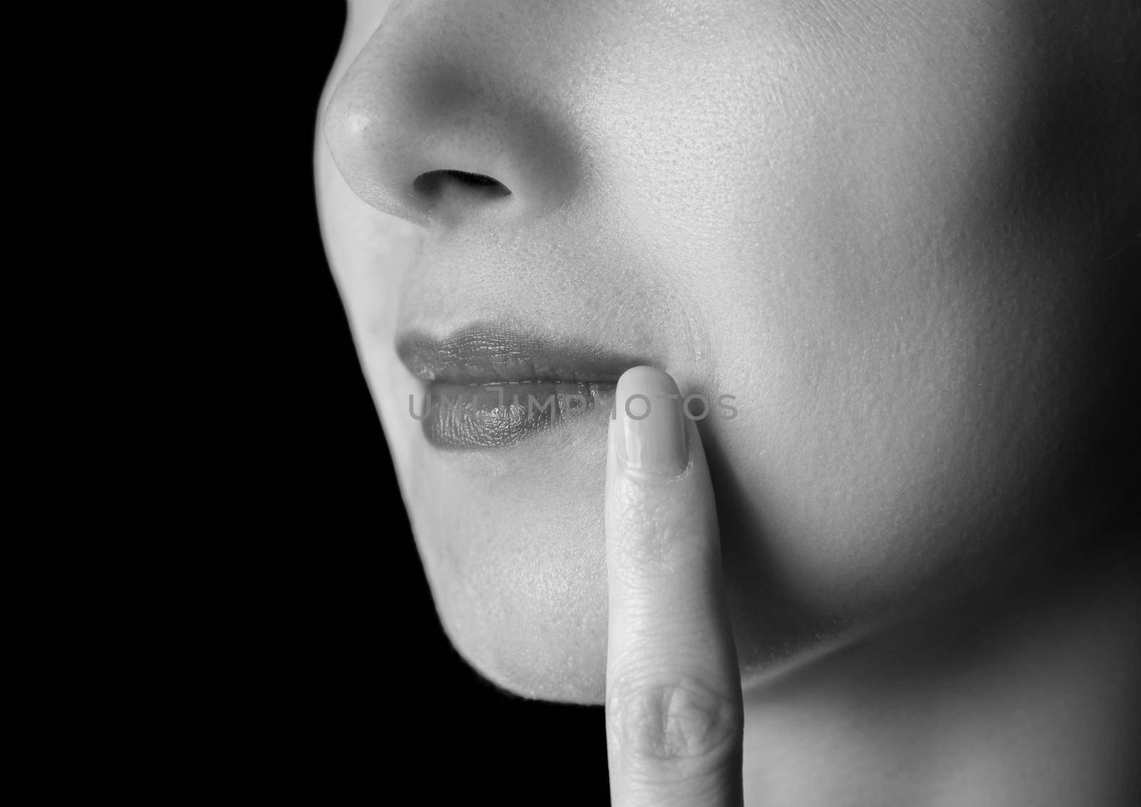 Unrecognizable woman is touching corner of lips, herpes on lip, monochrome image