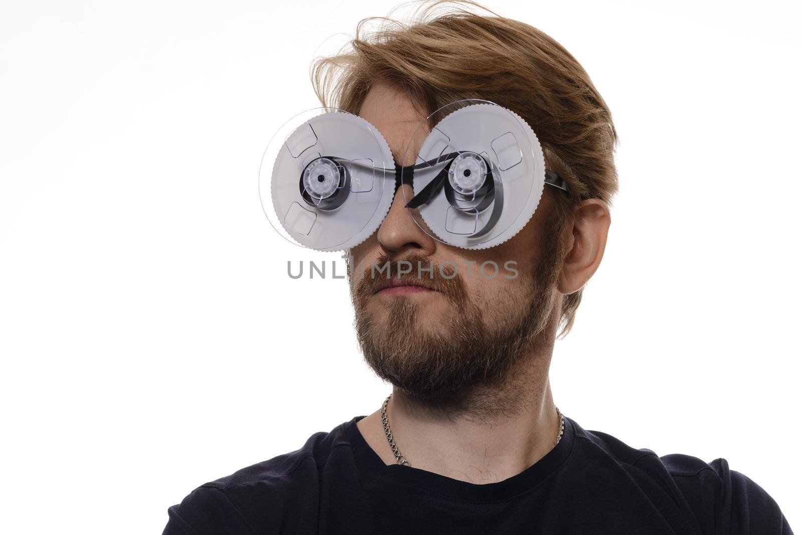 portrait of a man with glasses of tape reels of film on white background