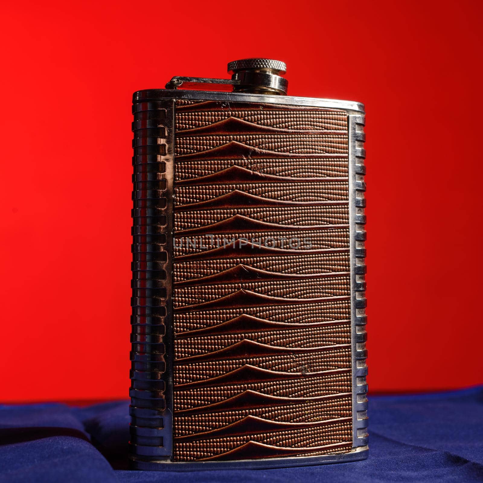 Stainless hip flask isolated on a blue background