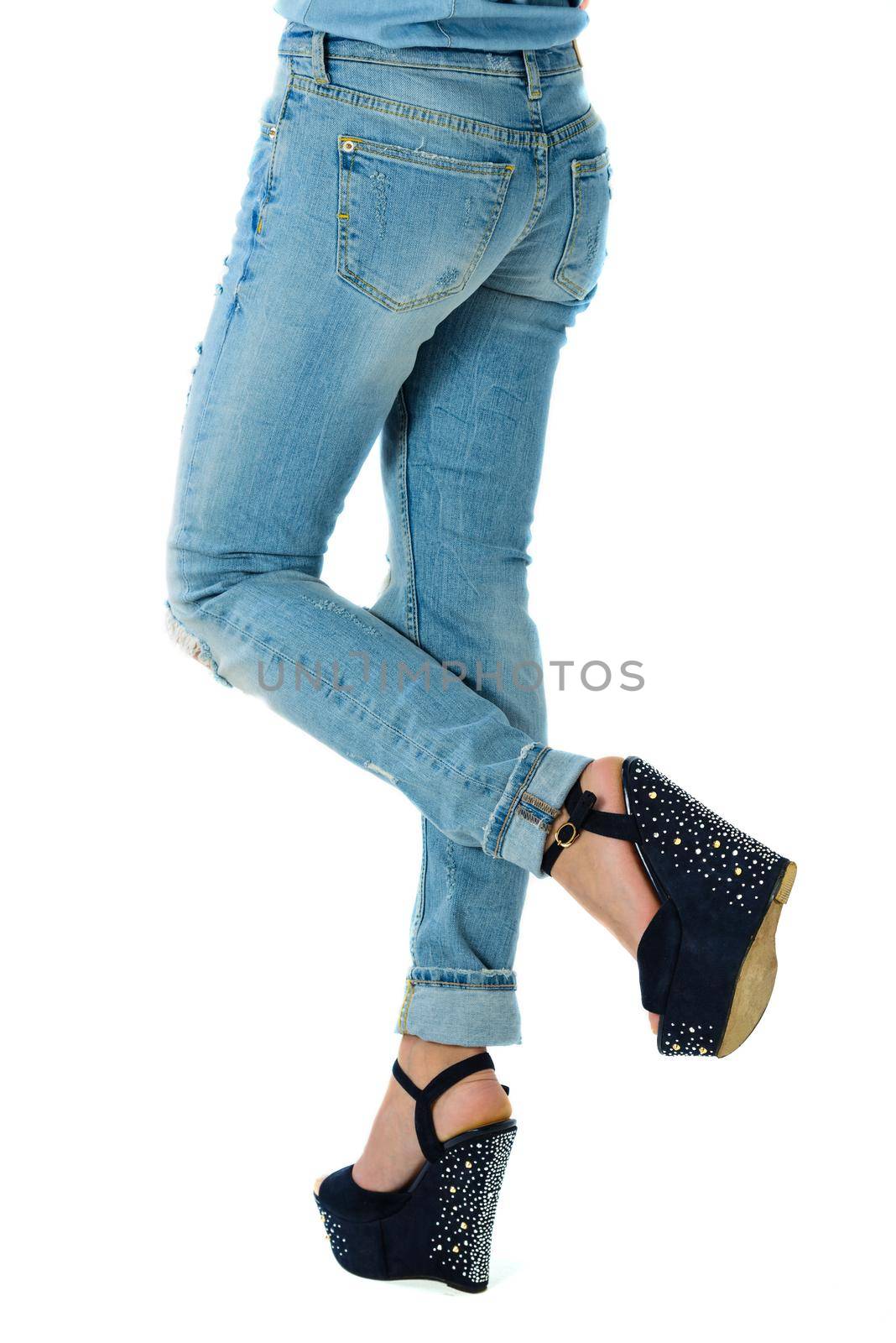 girl in jeans and high heels with studs and rhinestones on white background