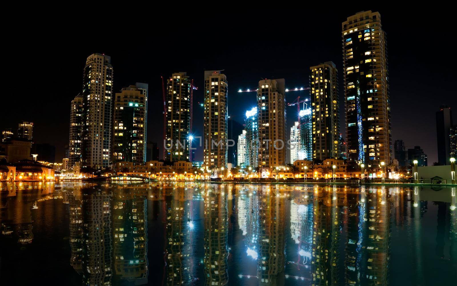 Colorful night view of city of Dubai with modern downtown buildings