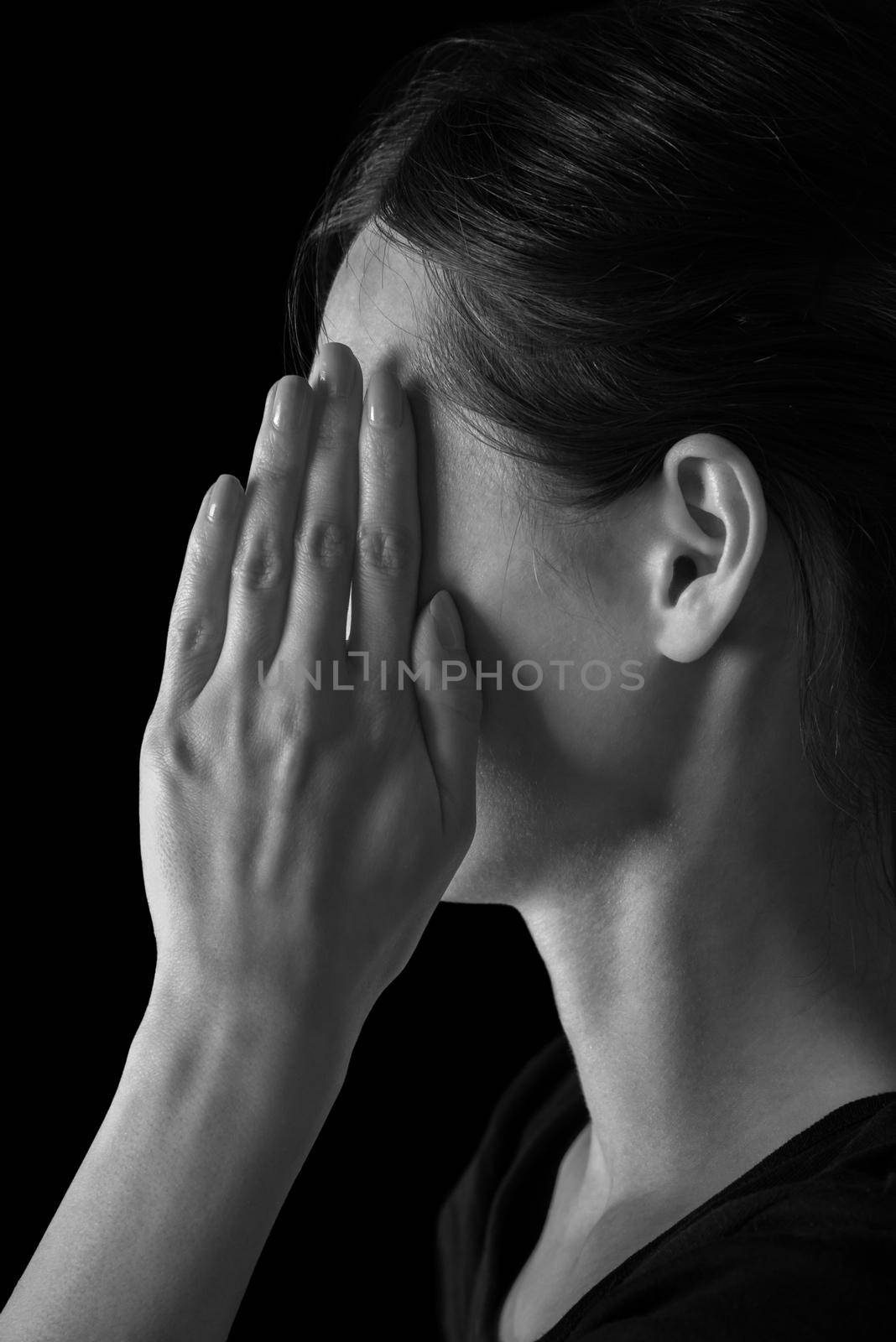 Woman closes her face by hand, tired woman, monochrome image
