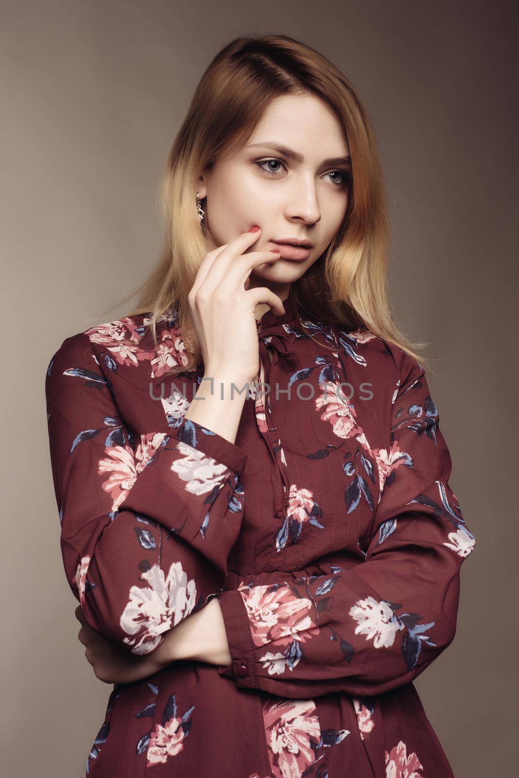 Portrait of a beautiful woman in a dress with floral pattern. Fashion photo