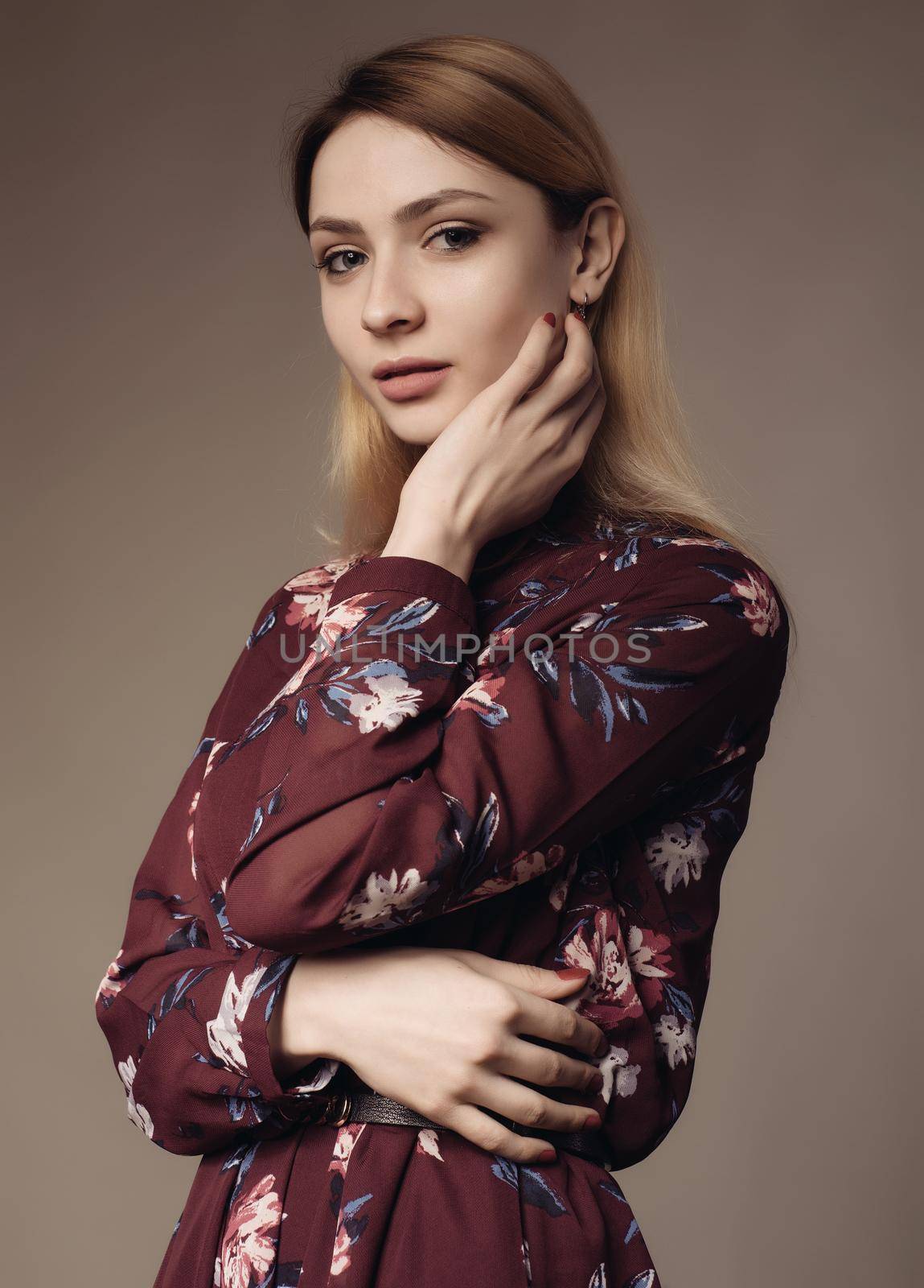 Portrait of a beautiful woman in a dress with floral pattern. Fashion photo