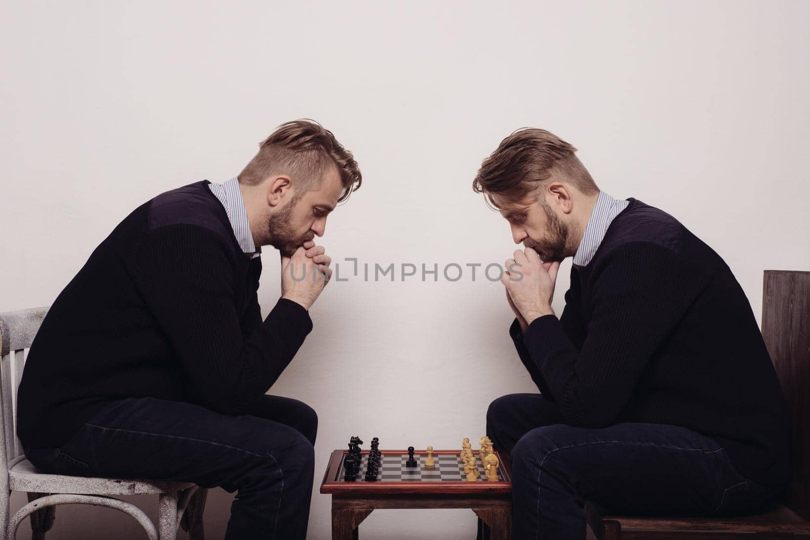 man playing chess against himself. thinks over the step