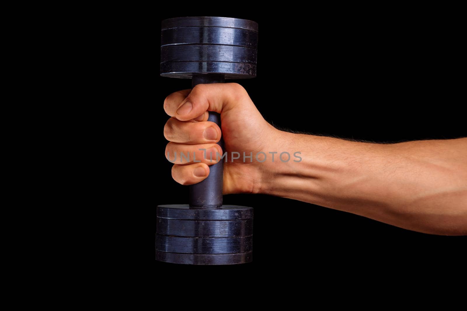 Male hand holds dumbbell on a black background