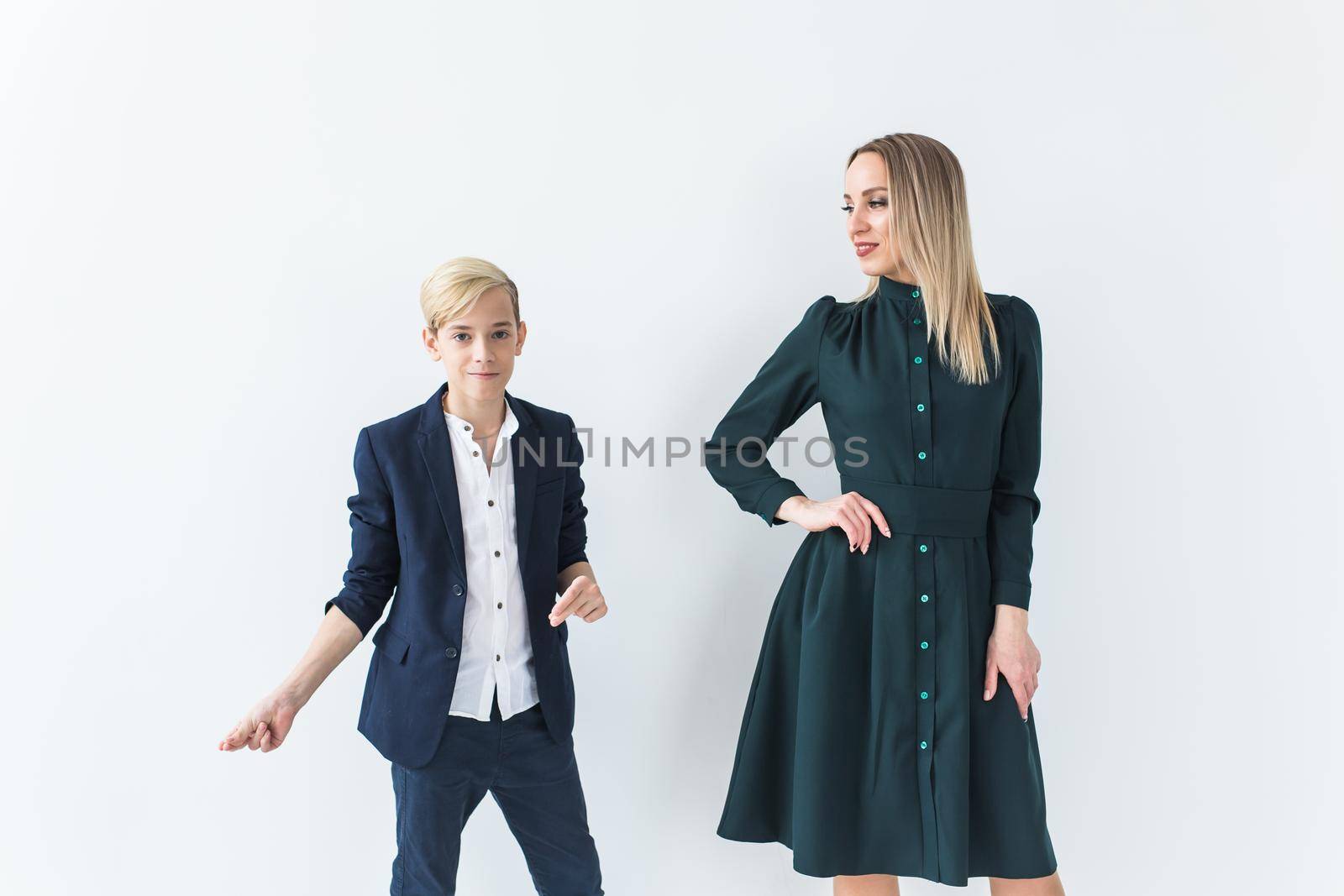 Teenager and single parent - Young mother and son standing together on white background