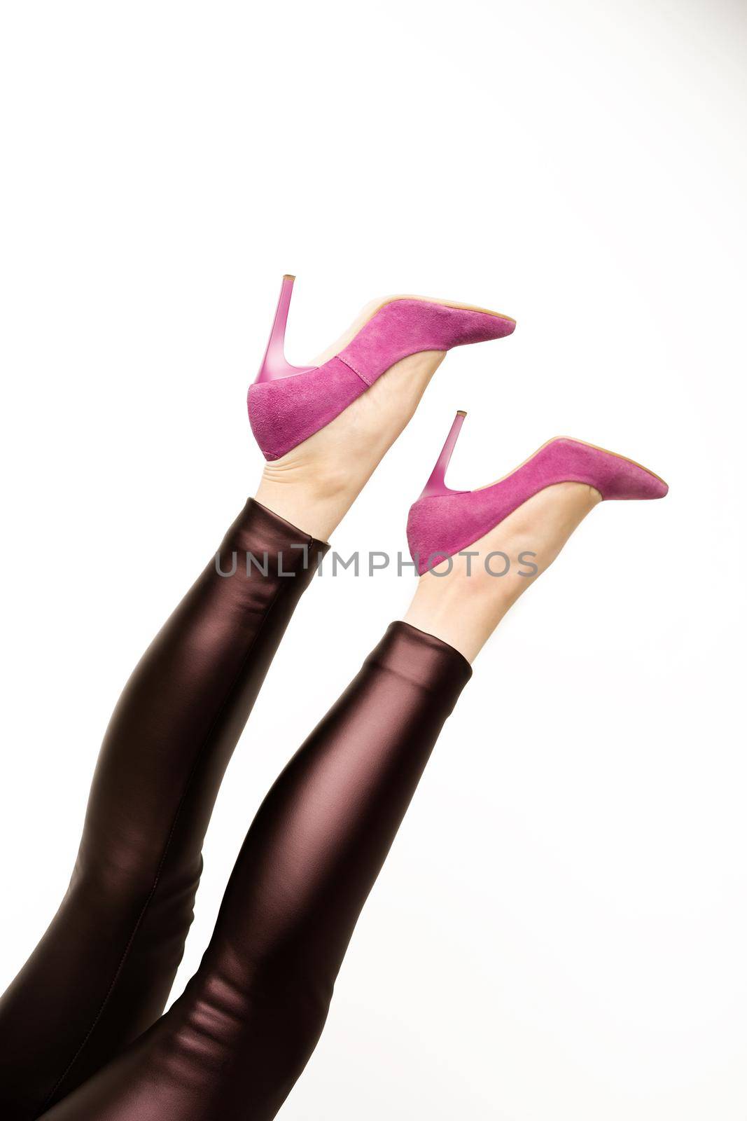 Woman in leather pants and pink high heels shoes on a white background. - image