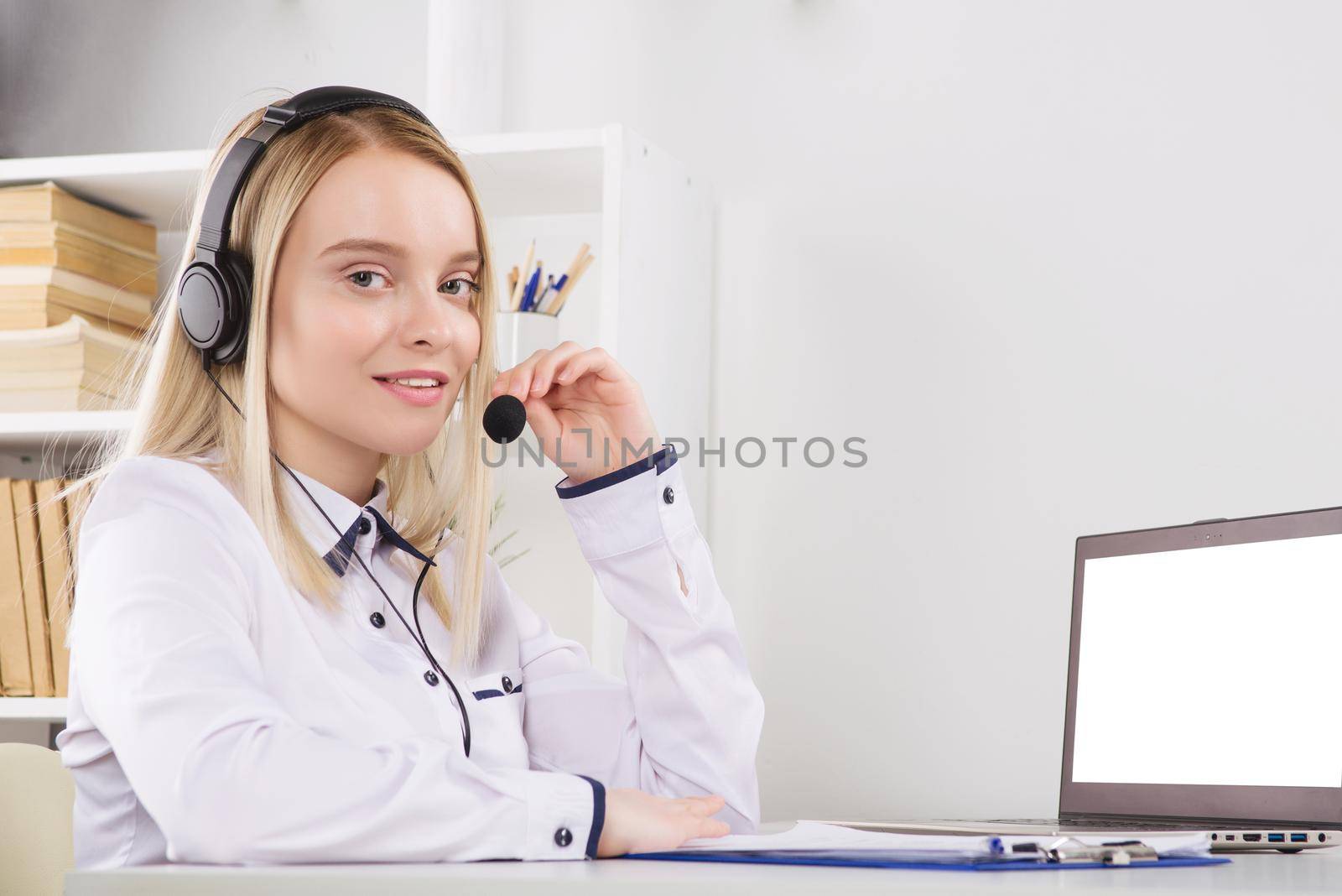 Portrait of happy smiling female customer support phone operator at workplace. - Image