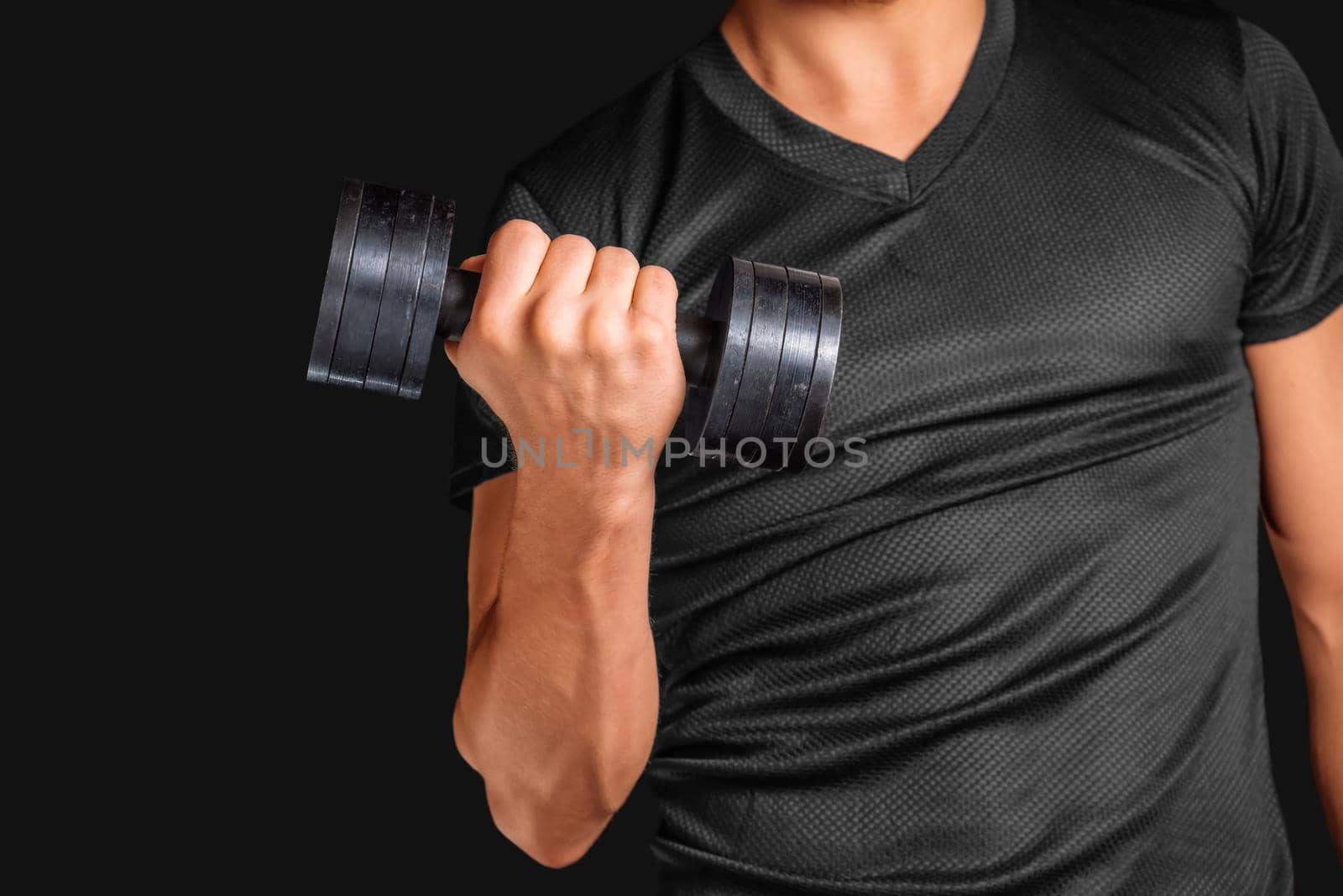 Unrecognizable man exercises with metal dumbbell