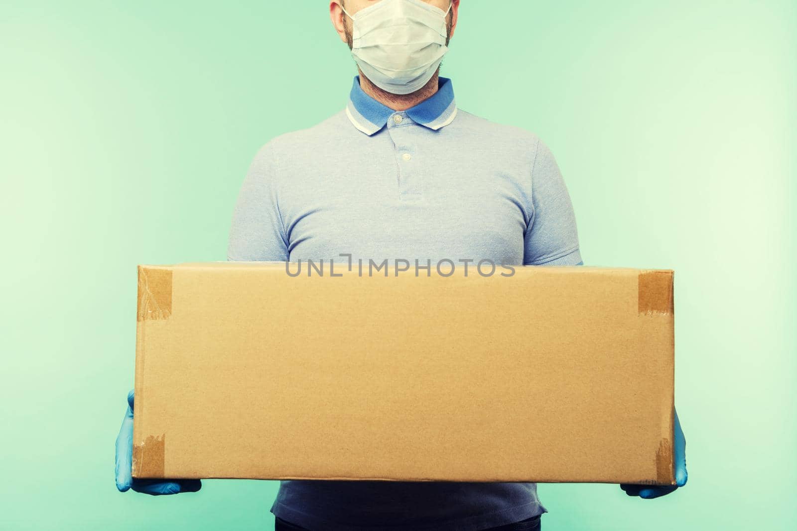 Man holding cardboard boxes in medical rubber gloves and mask. Coronavirus pandemic quarantine delivery concept