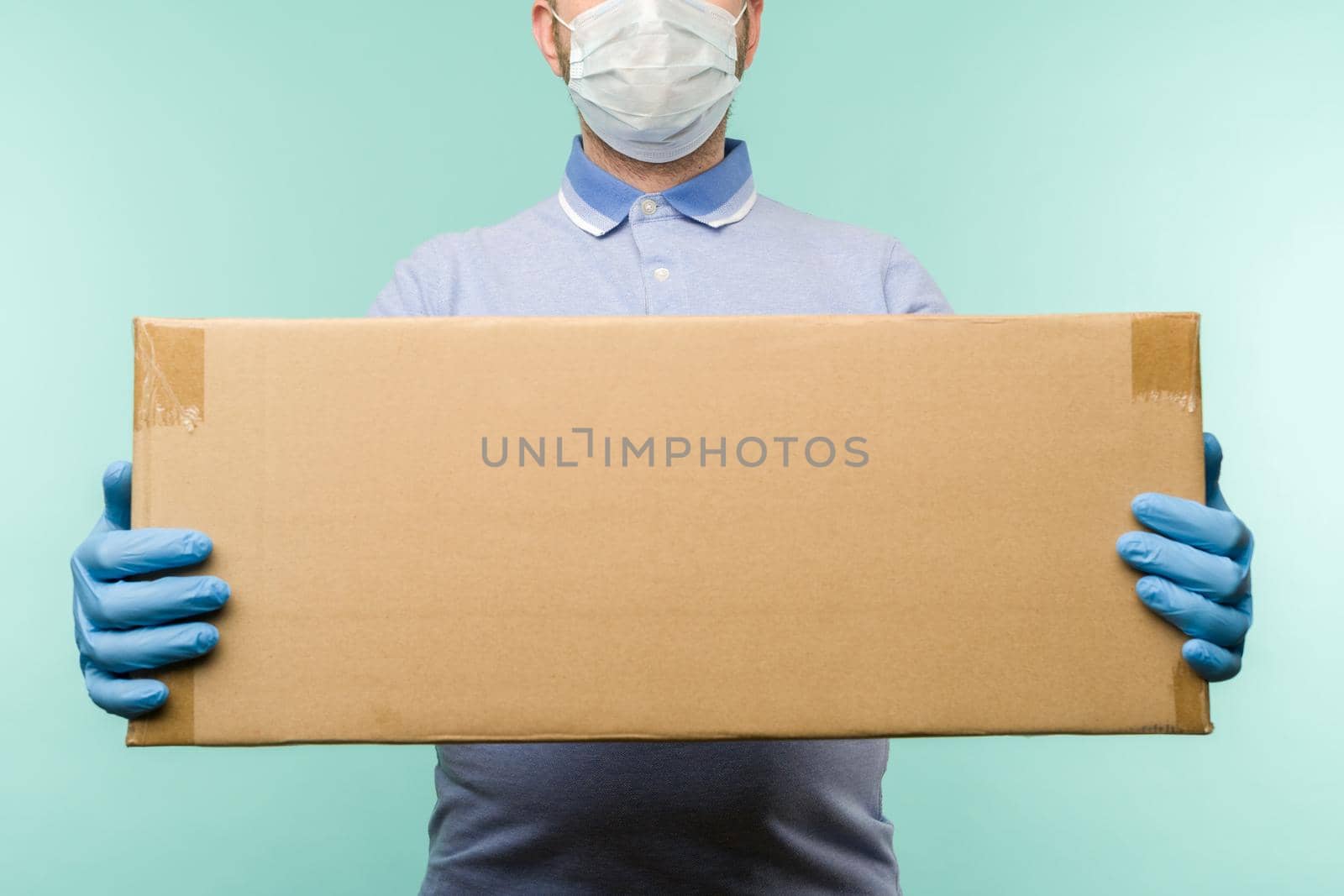 Man holding cardboard boxes in medical rubber gloves and mask. by zartarn