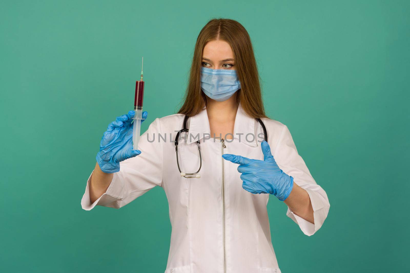 Covid19, coronavirus. Portrait of professional confident young caucasian doctor in medical mask and white coat, stethoscope over neck,with vaccine syringe in hand, fight disease - image