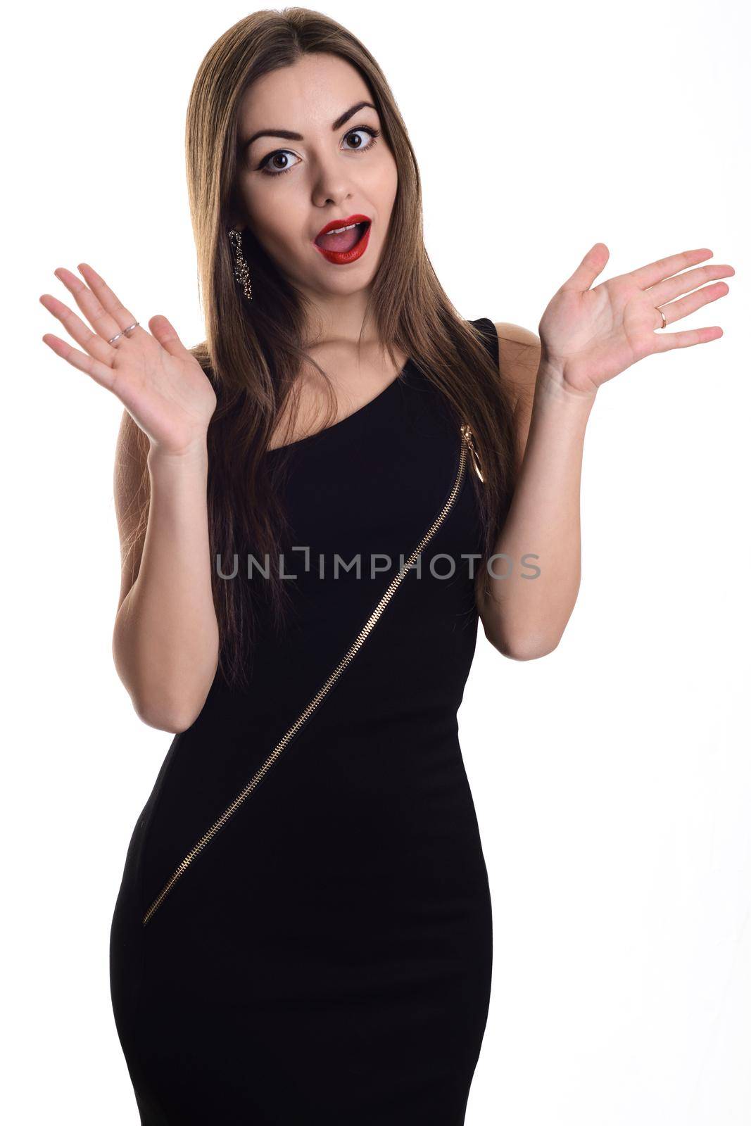 Stylish girl in black evening dress standing with hermouth open in surprise, and hands outstretched to the sides.