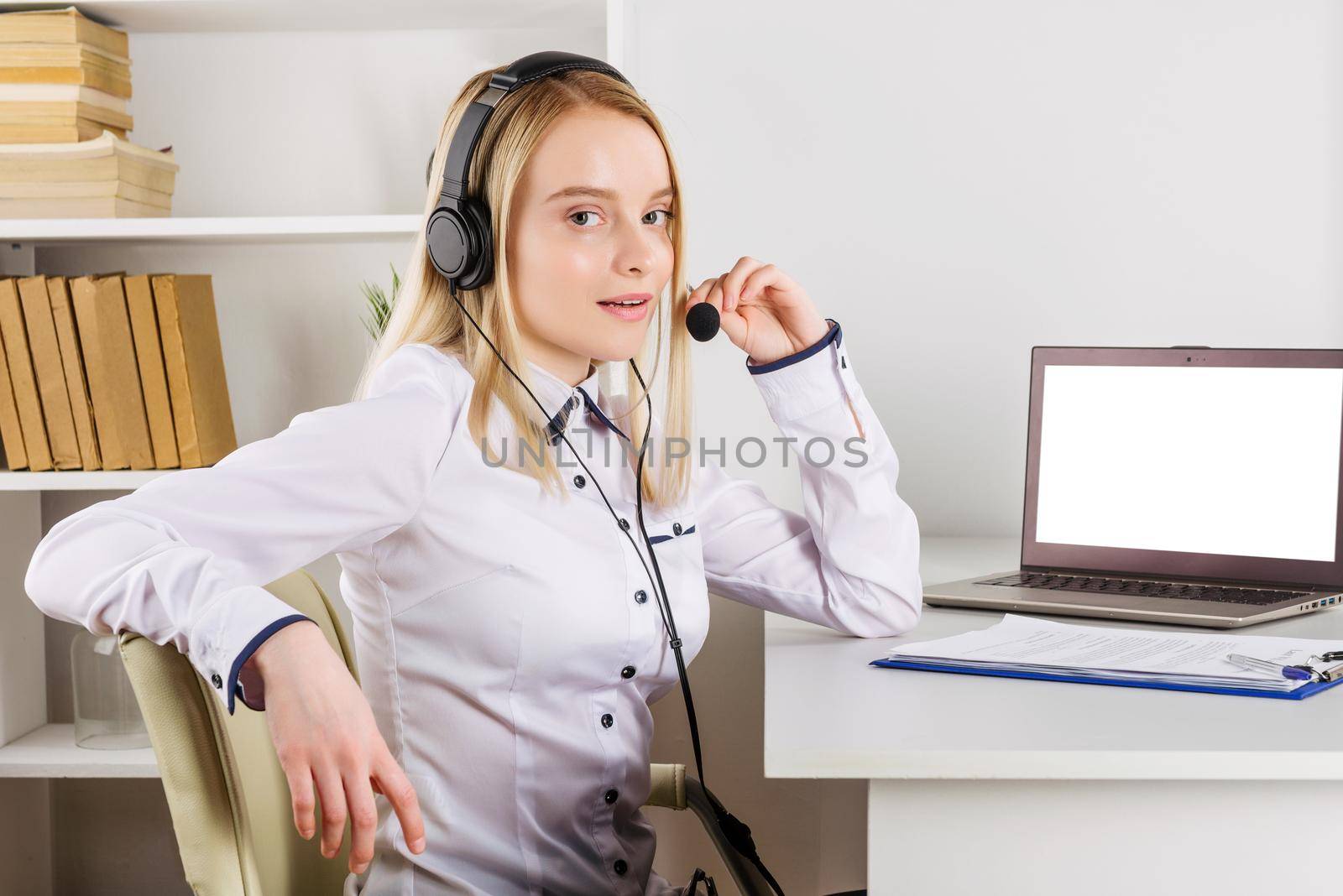 Portrait of happy smiling female customer support phone operator at workplace. - Image