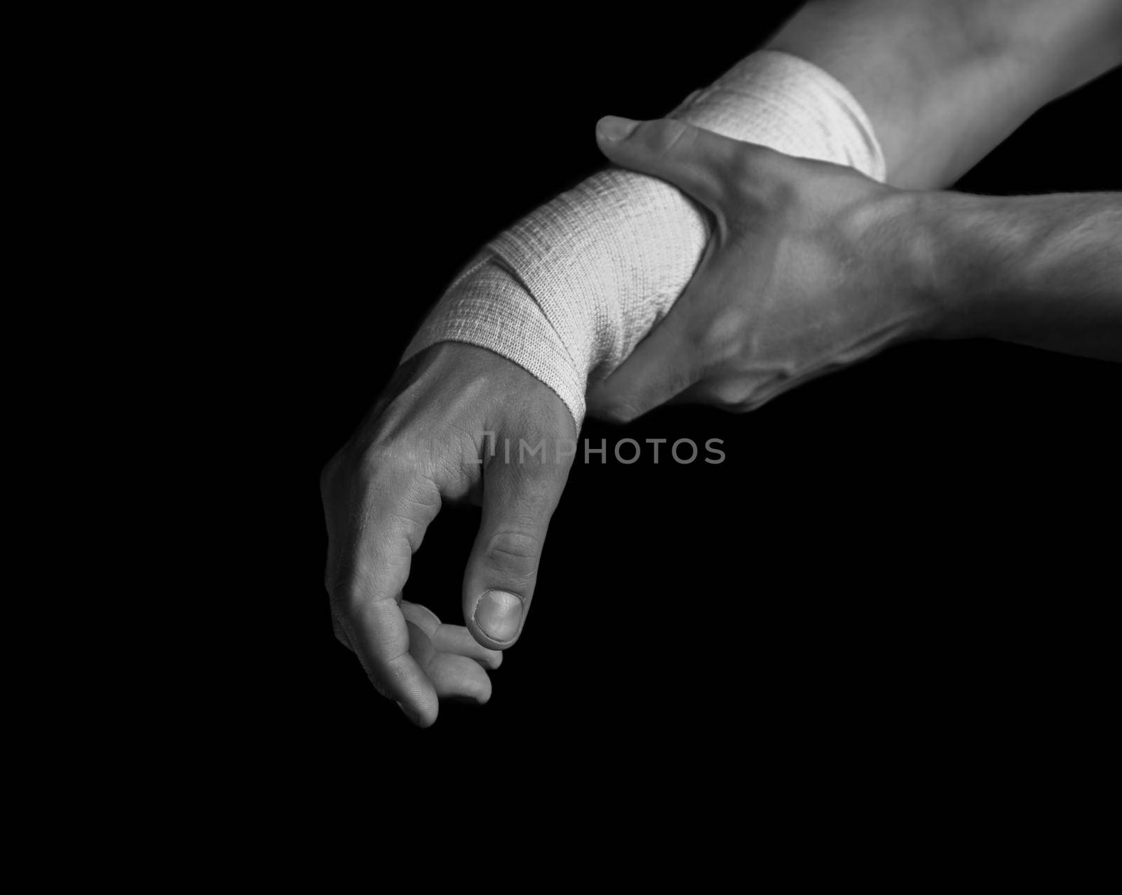 Pain in a male wrist, bandaged hand, black and white image