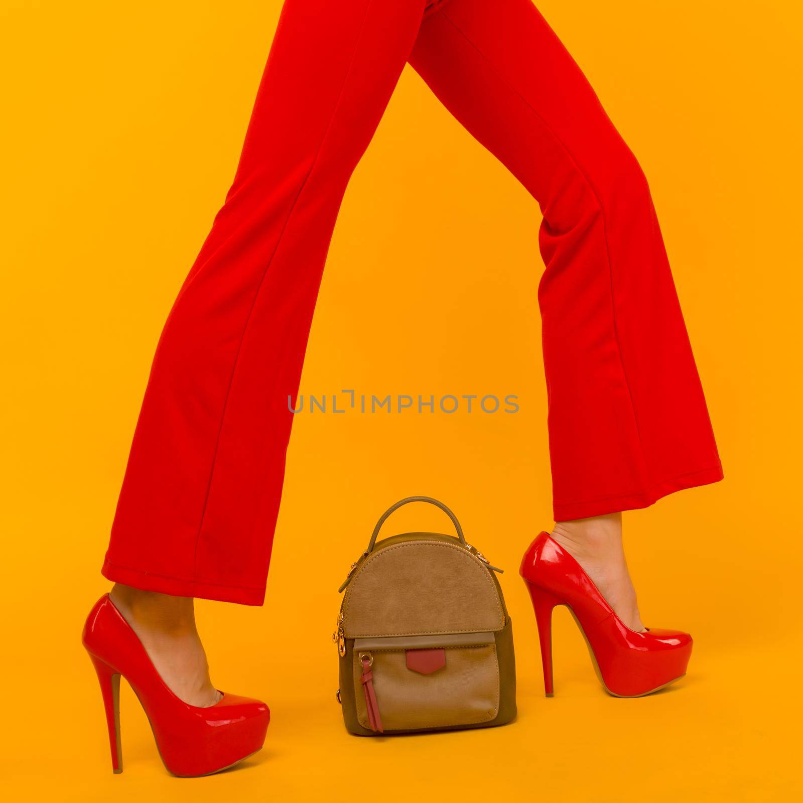 Woman fashion with beautiful small backpack handbag with red high heels shoes on yellow background - image