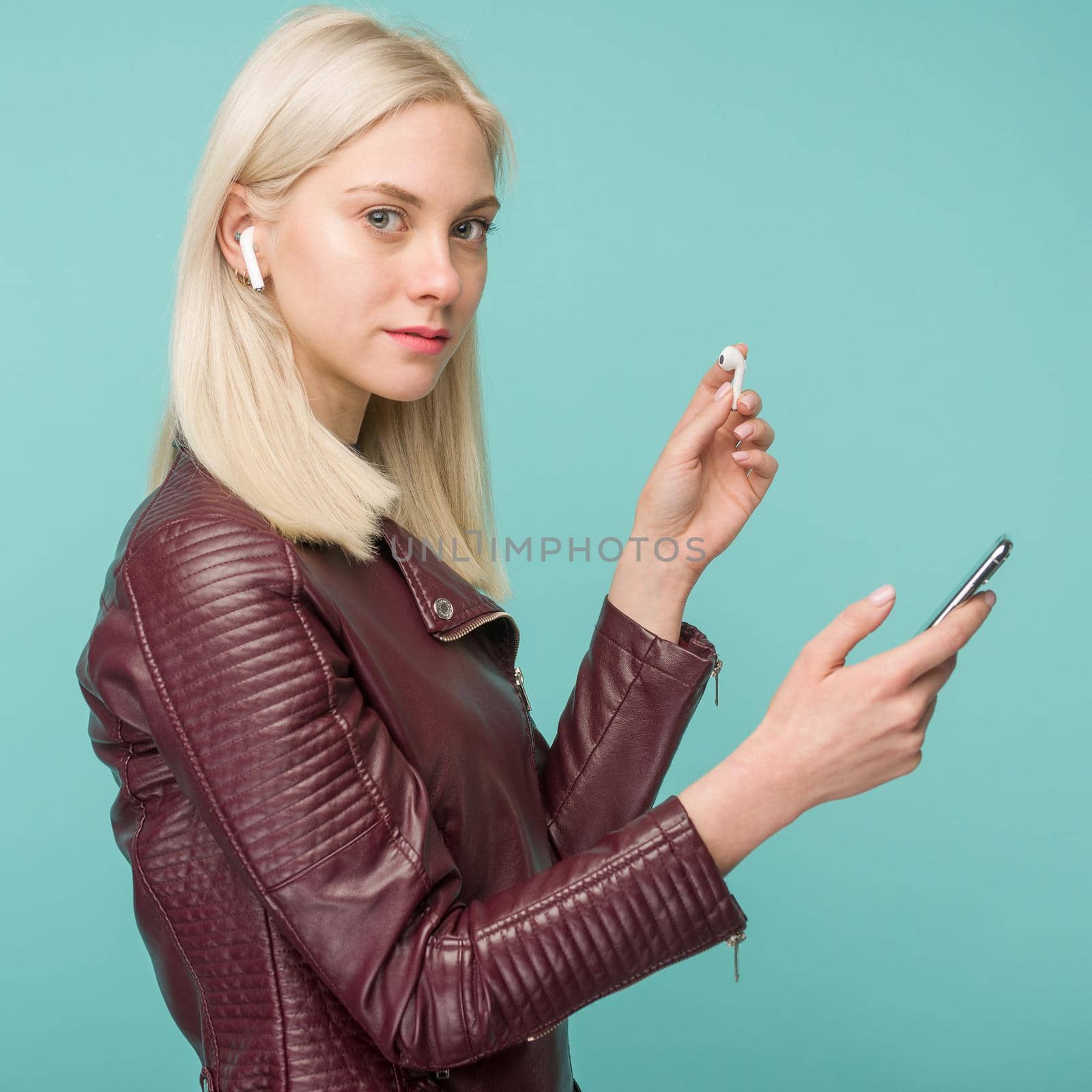 Tula, Russia - May 1, 2019: Happy woman listening music Apple AirPods wireless . by zartarn