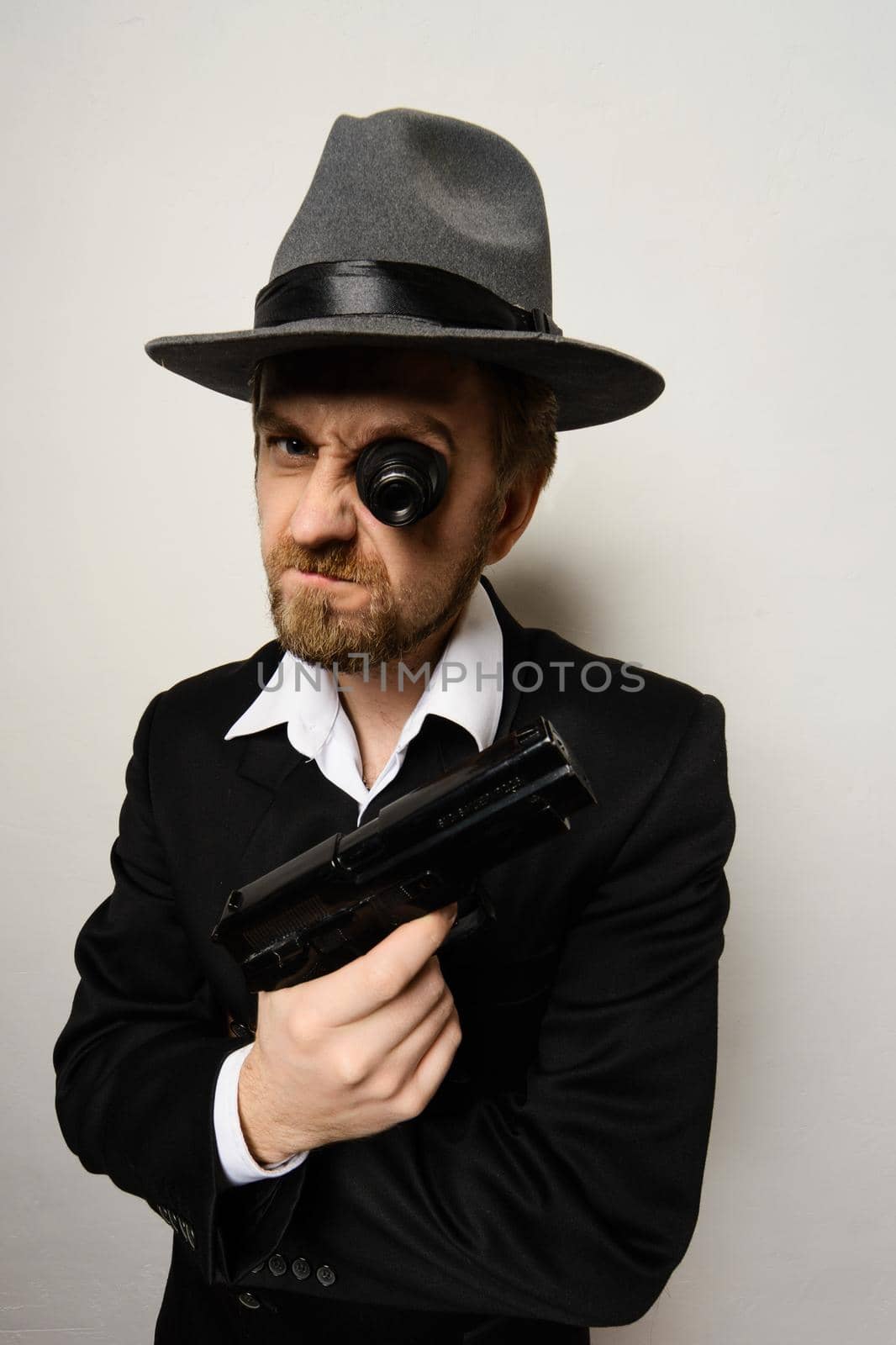 crazy beard detective whit gun in hat at white background