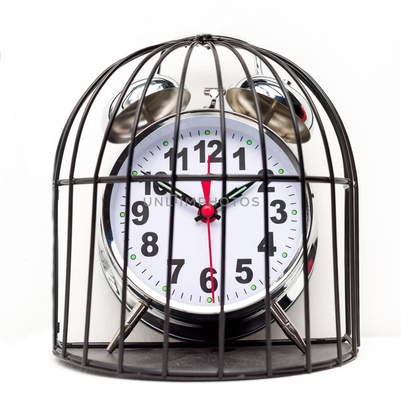 Concept of imprisonment. Alarm clock locked in a cage. - image
