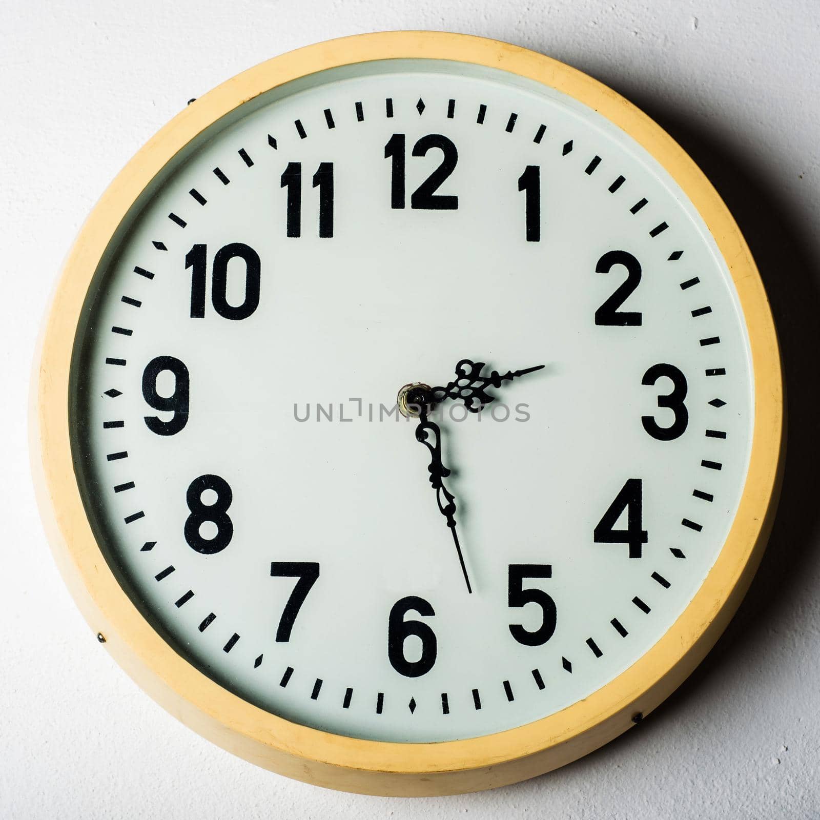 old round station clock on the white wall.