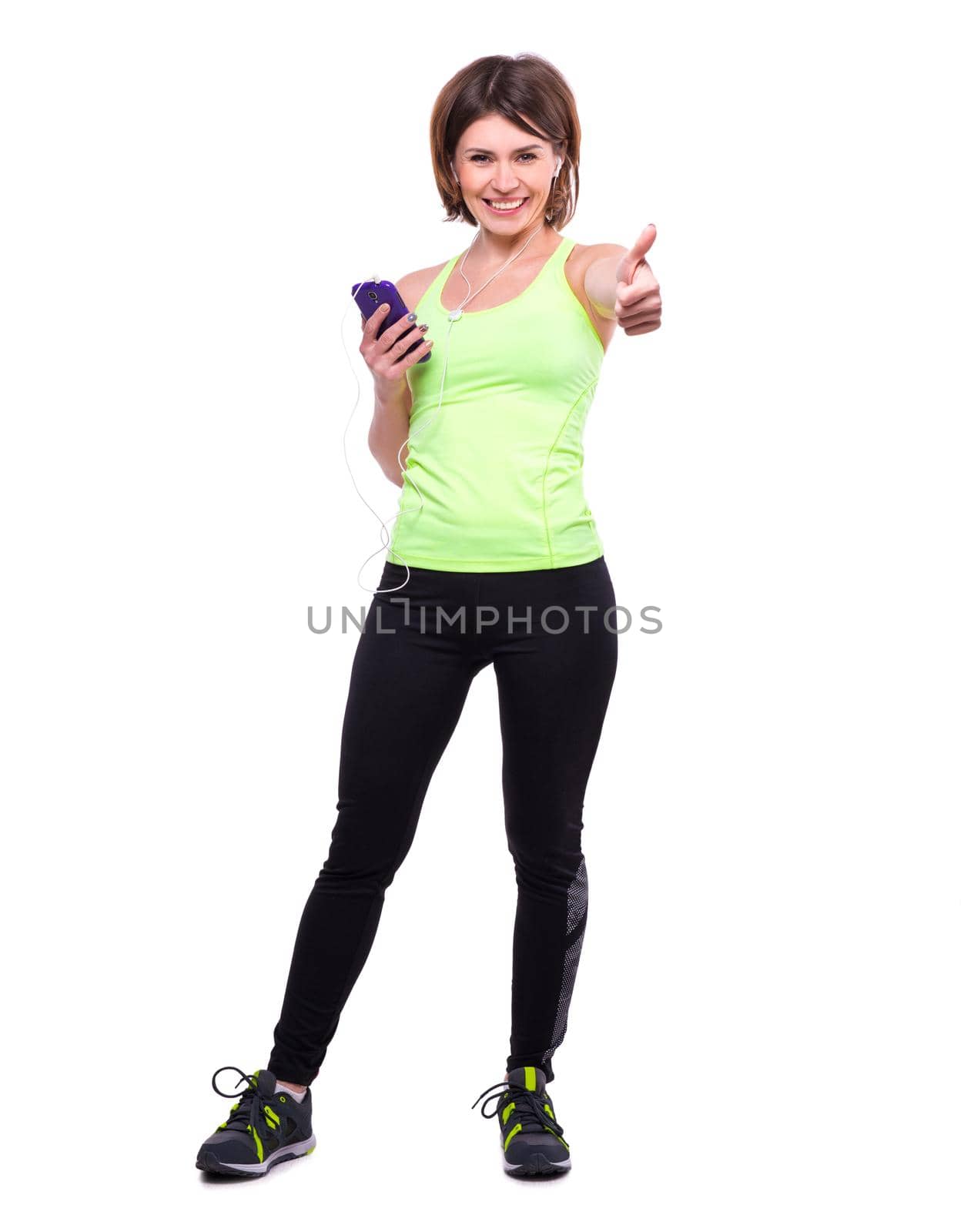 smiling sport woman with mobile and with her thumb up on white background