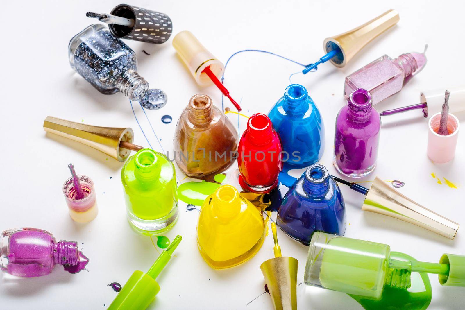 Colored nail polish on a white background. lacquer spray on background