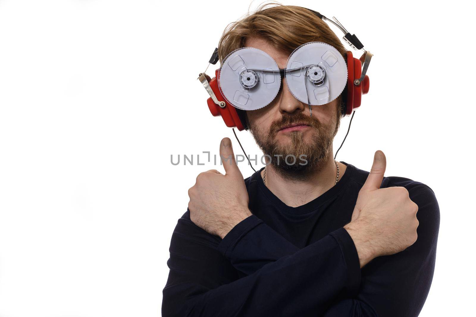 portrait of young man with glasses of tapes listen to music on white background thumbs up