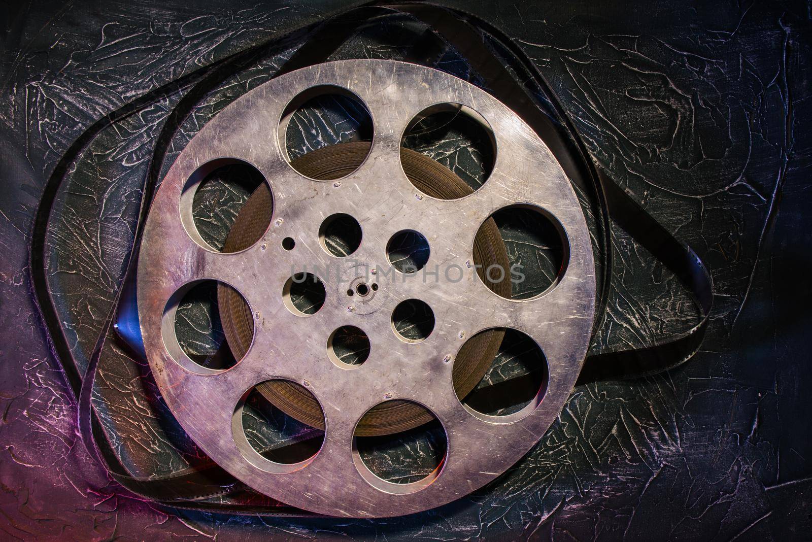 35 mm film reel with dramatic lighting on a dark background - image