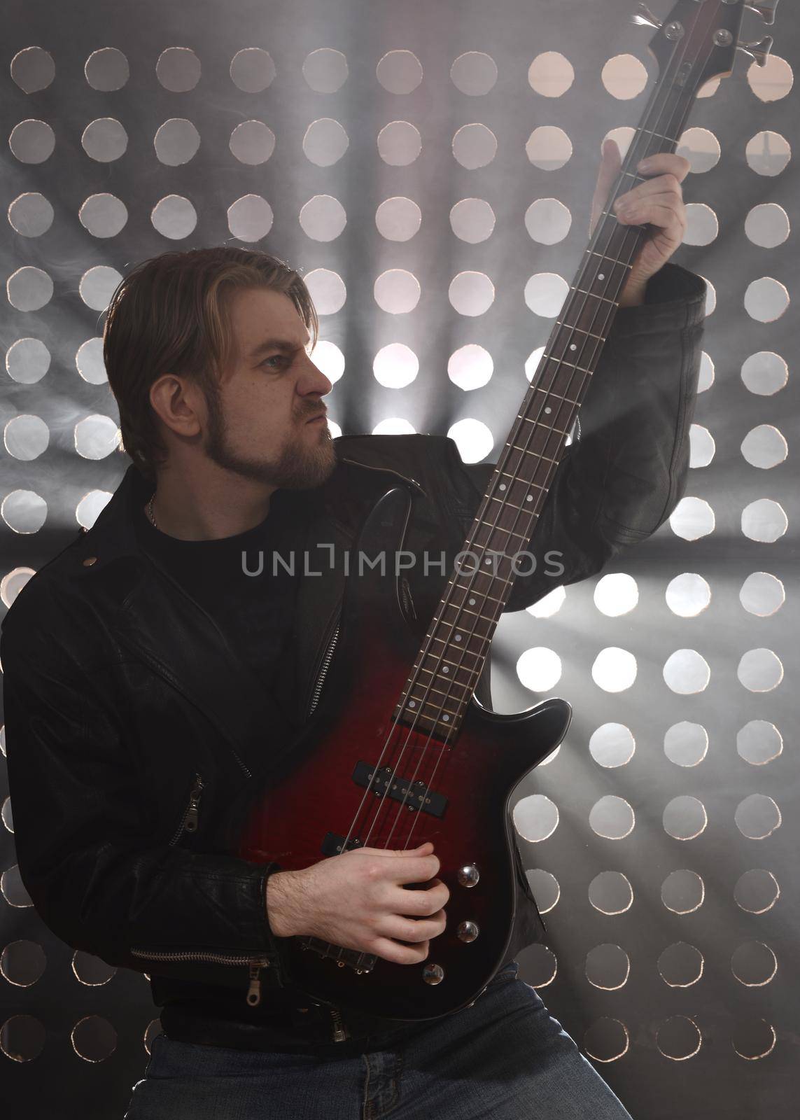 Bassist playing bass guitar in smoke. backlight