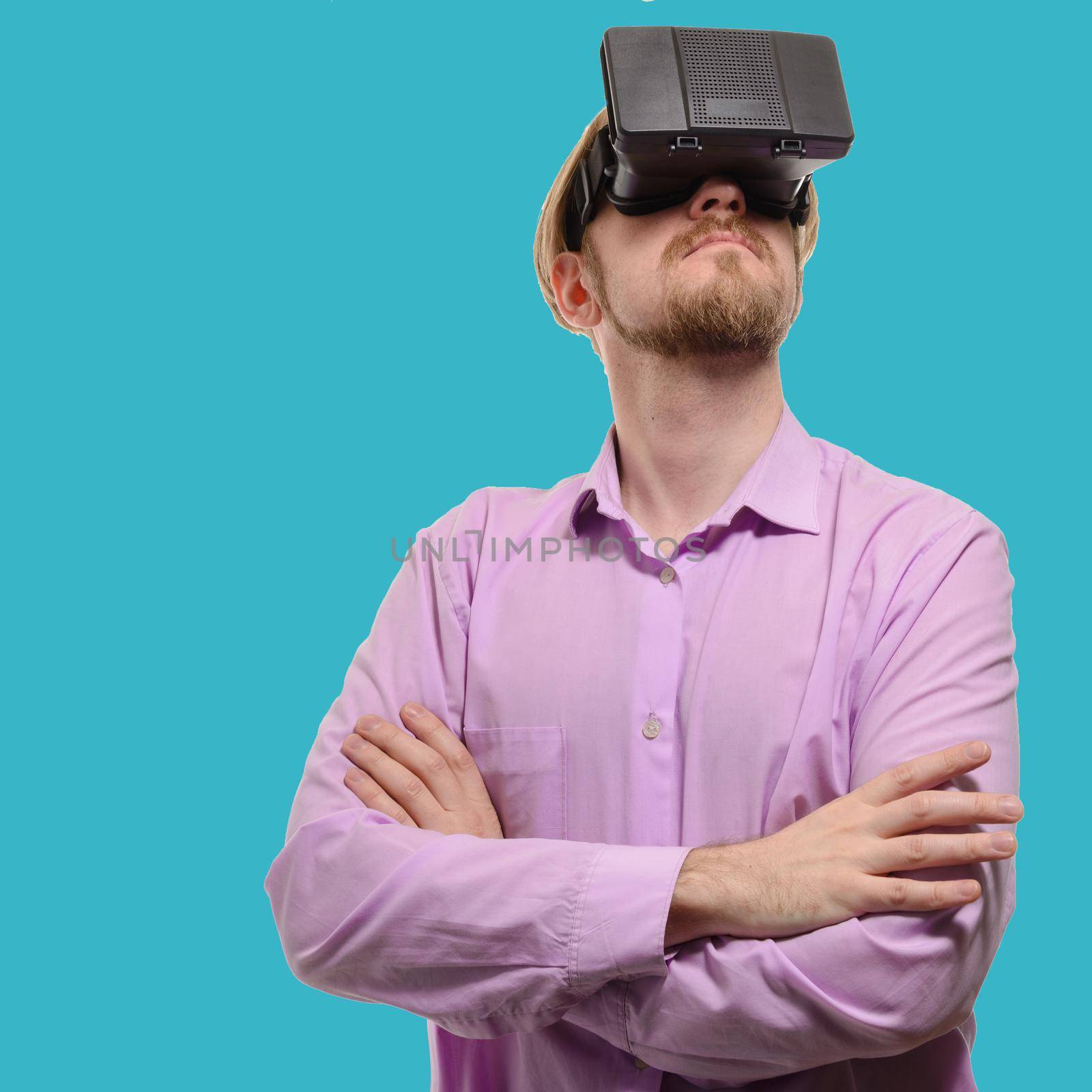 nice man with glasses of virtual reality in a lilac shirt on blue background.