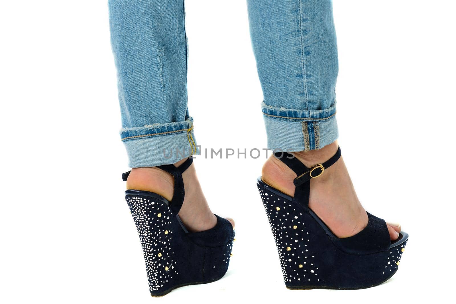 girl in jeans and high heels with studs and rhinestones on white background