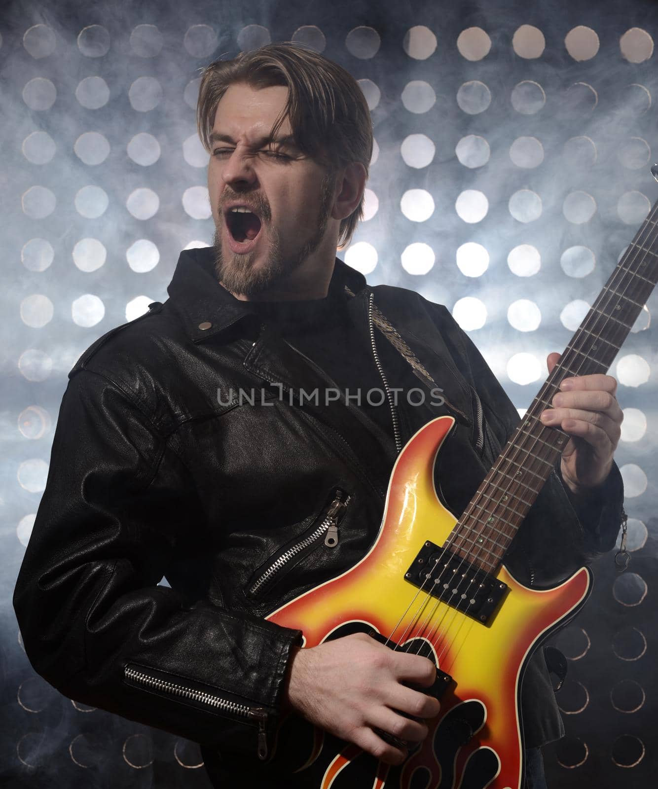 rock guitarist playing electric guitar in fog