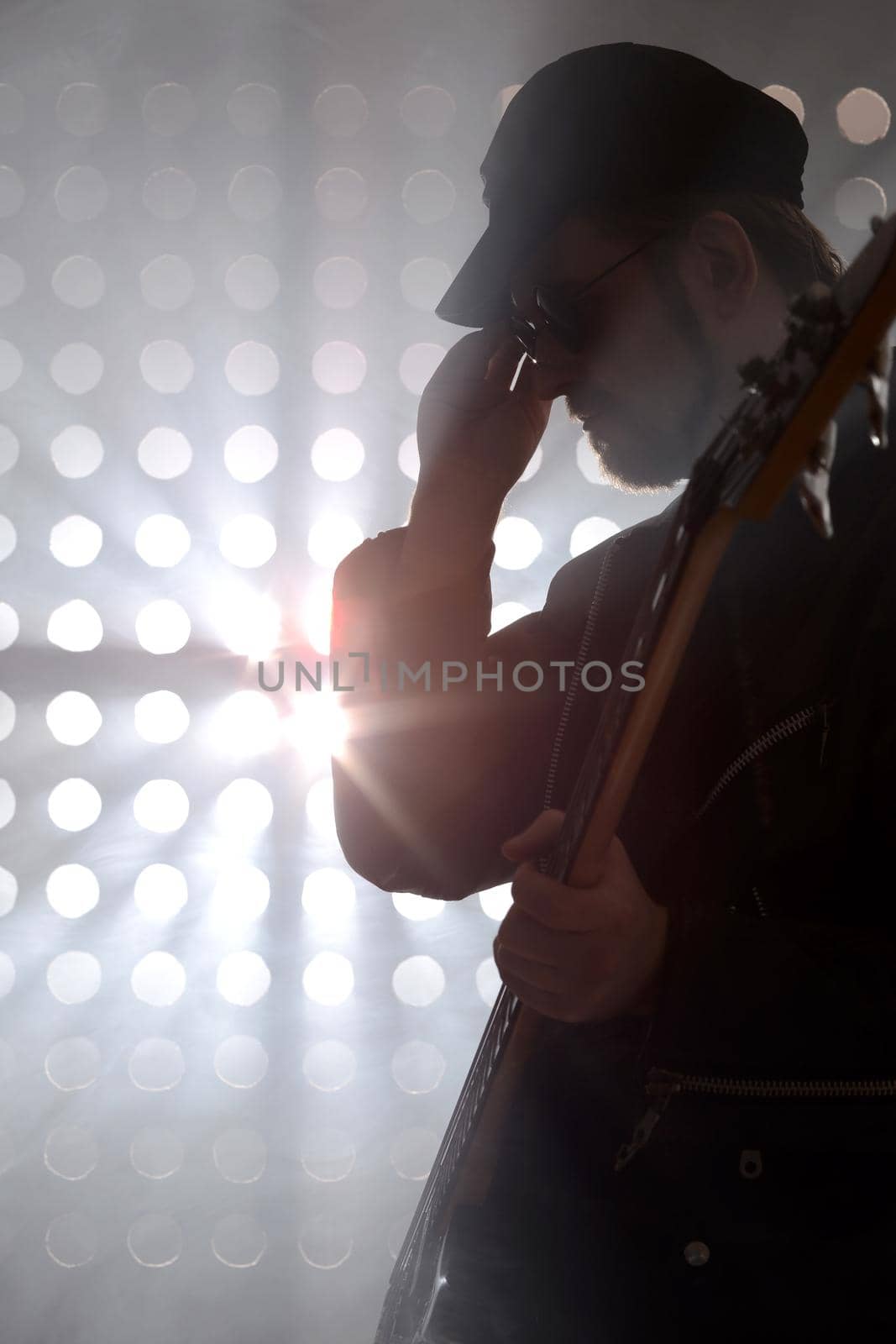 Bassist playing bass guitar in smoke. backlight