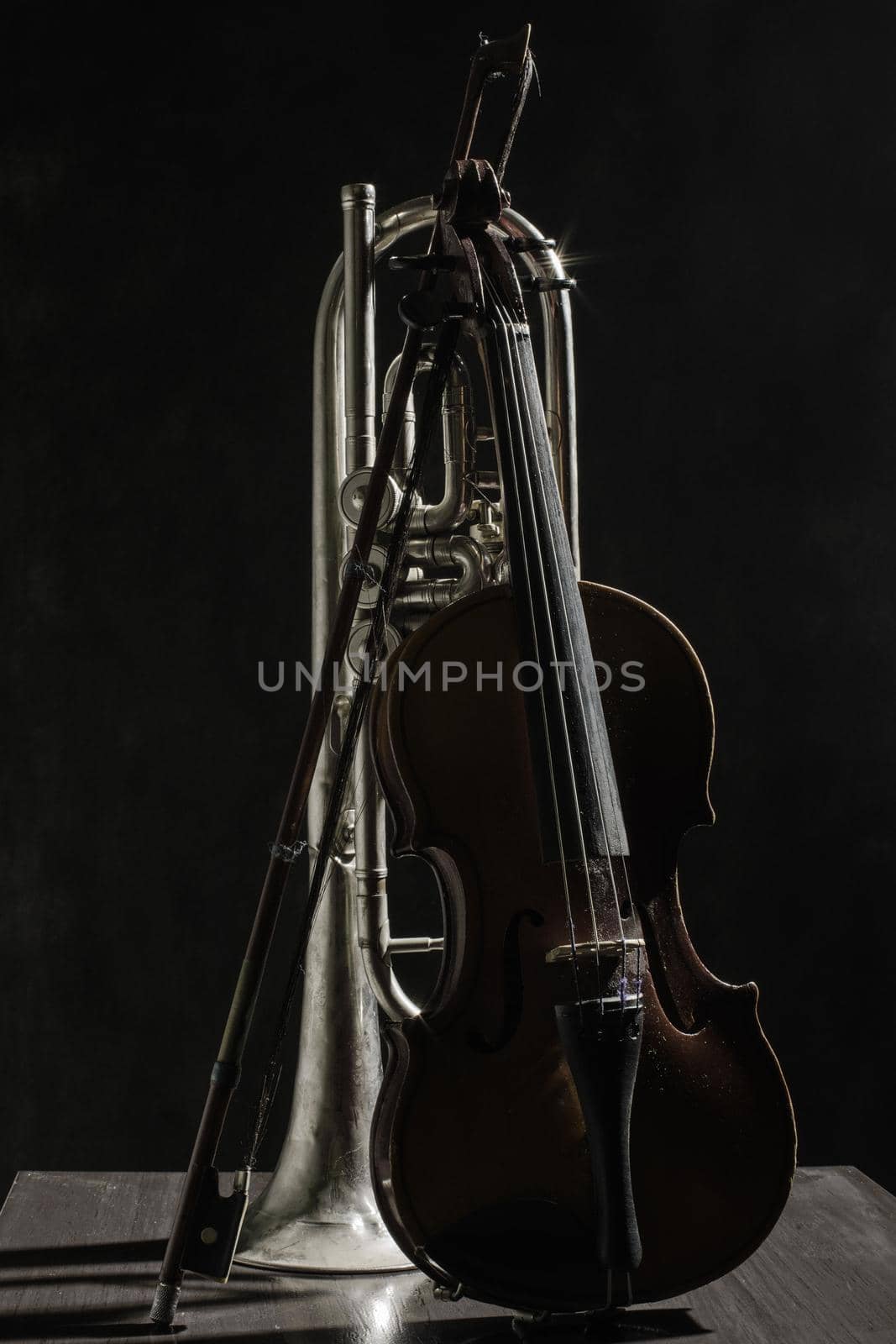 Old violin bow and broken pipe on a black background. by zartarn