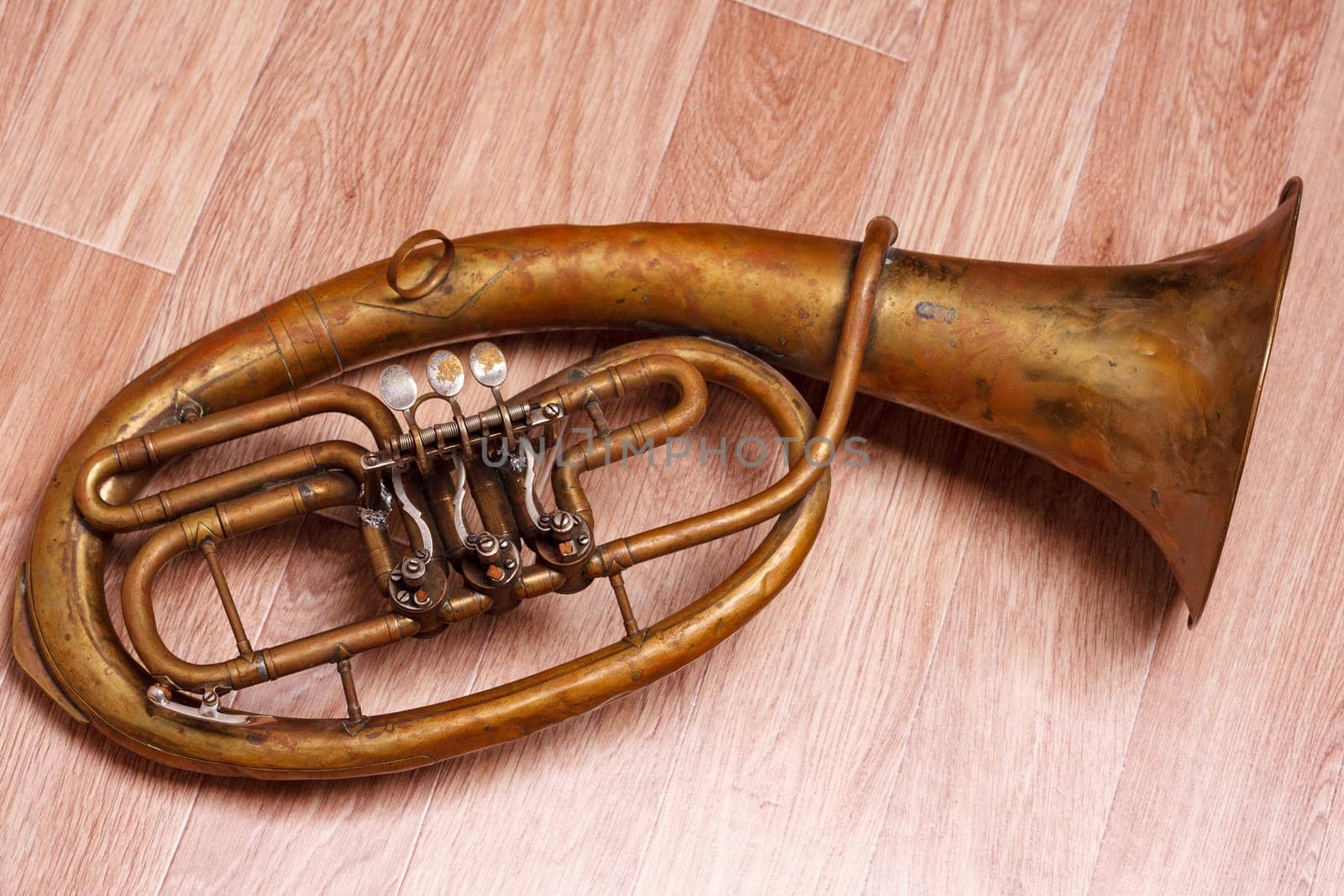 old rusty alto saxhorn on wooden background.