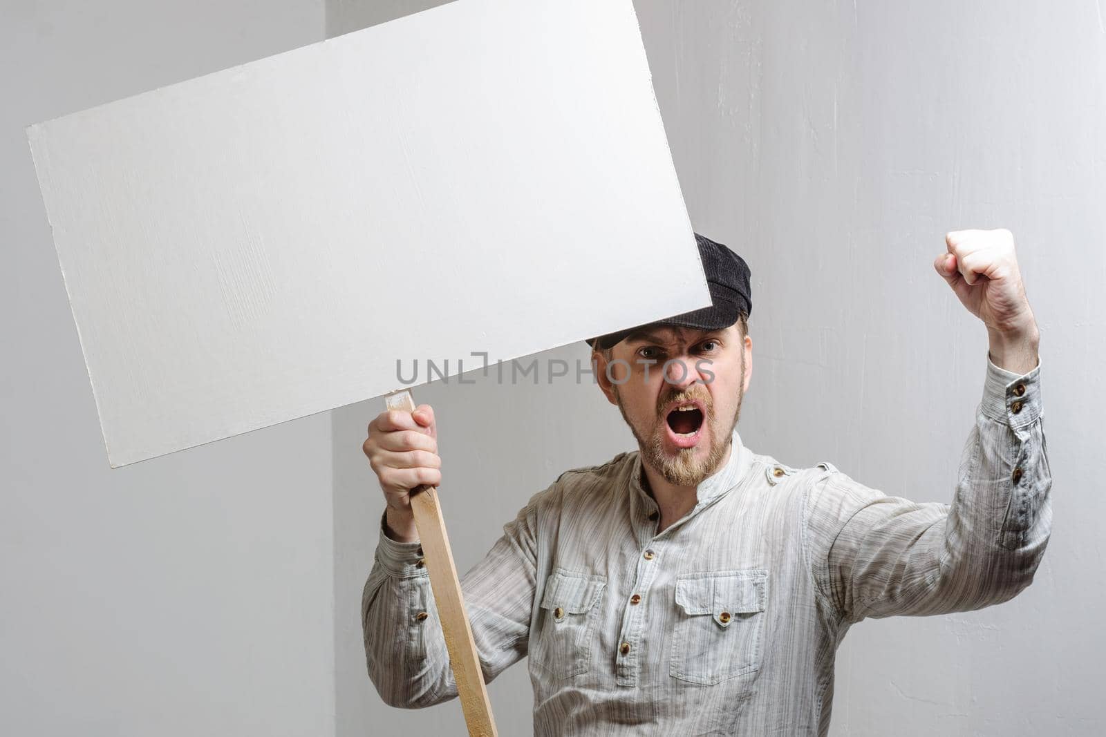 Angry protesting worker with blank protest sign.