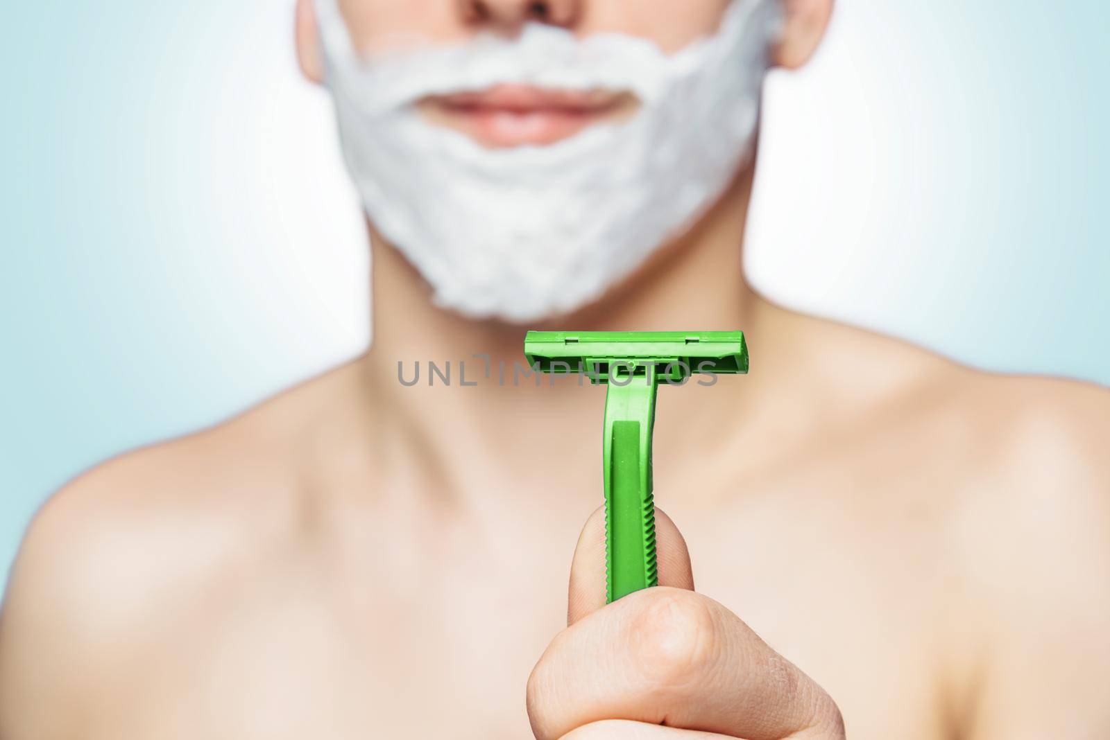 Man holds green razor by alexAleksei