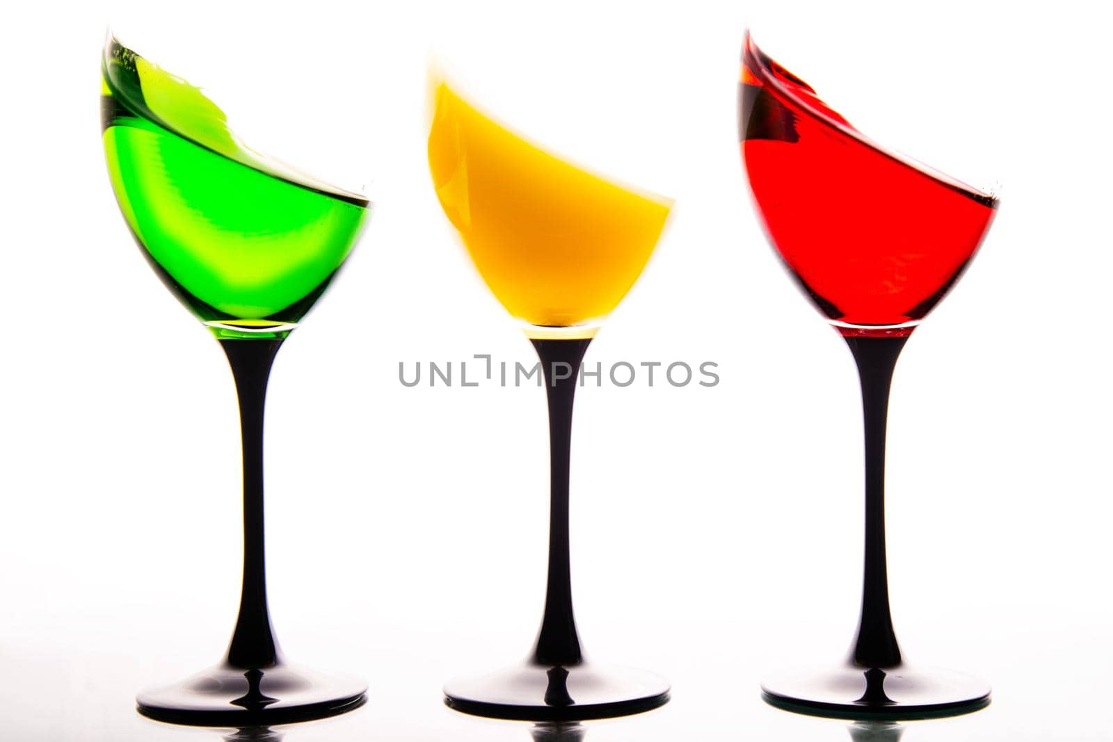three wine glasses filled with the colors of traffic lights.