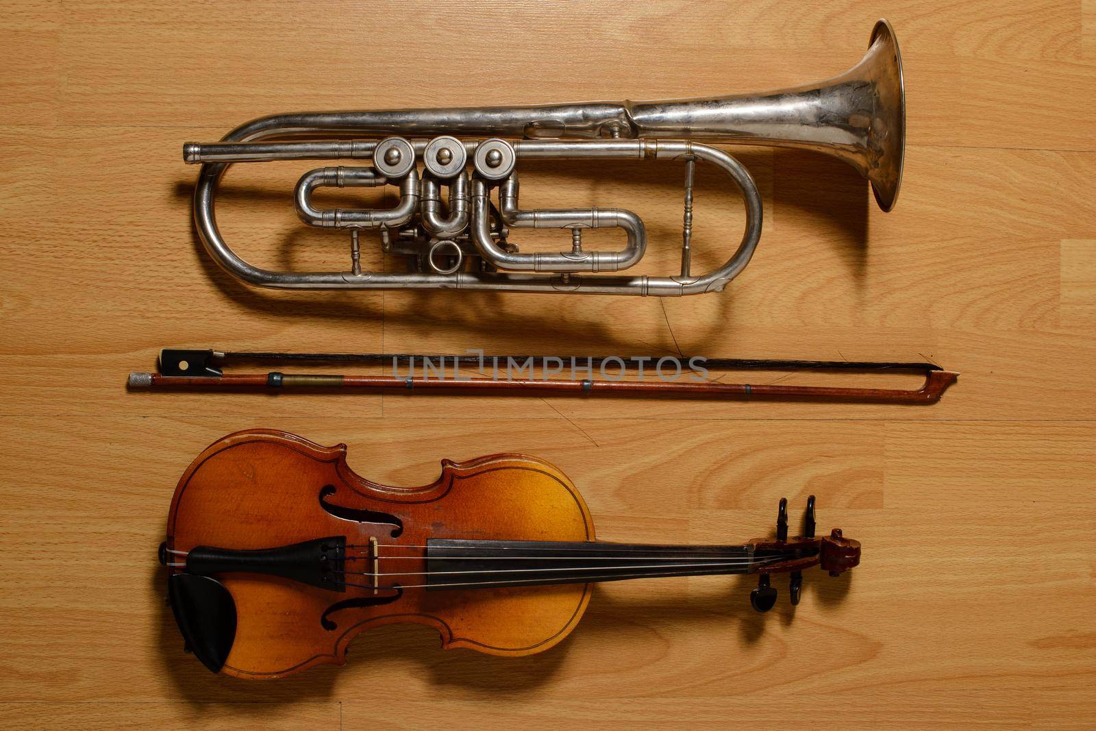 Broken trumpet and violin on the wooden floor.