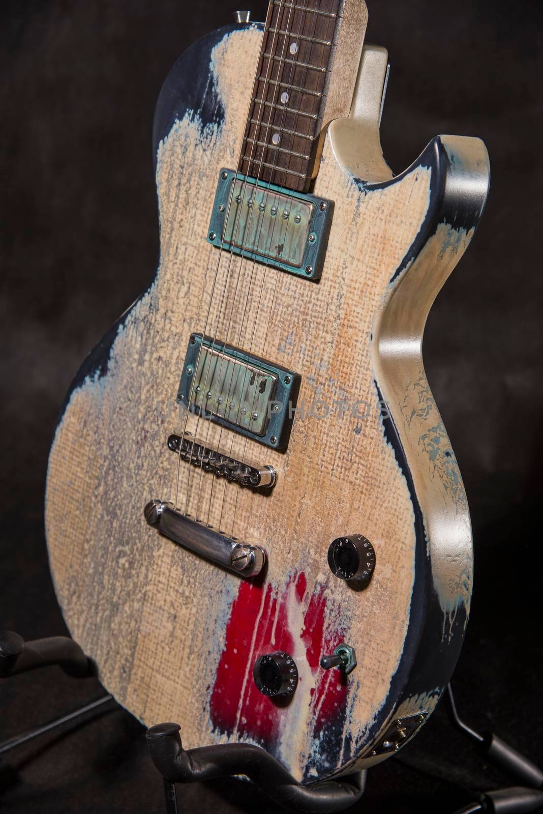 Aged guitar front on black background
