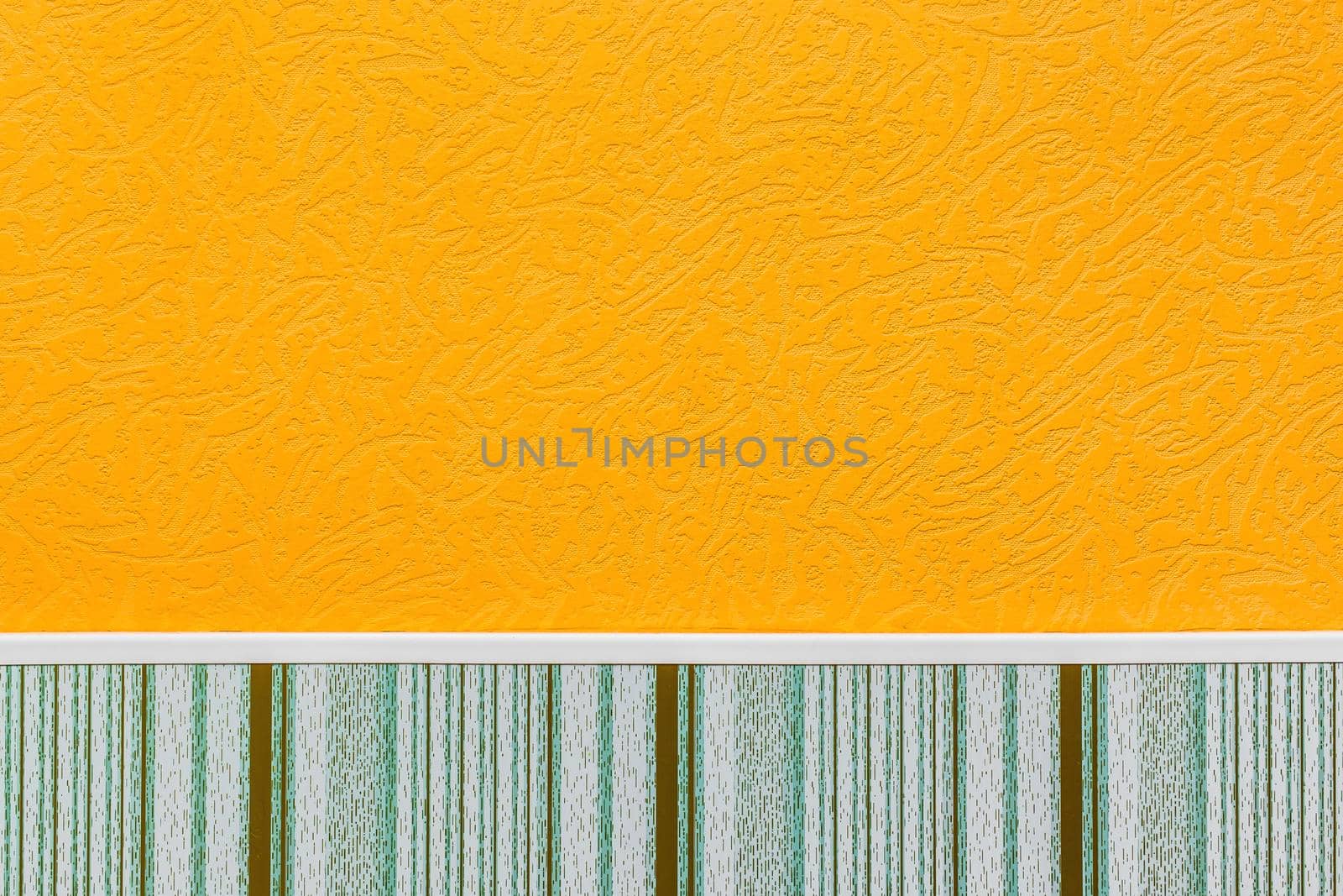 Element or part of wall of modern interior with orange wallpaper with abstract pattern and plinth with vertical lines texture background by AYDO8