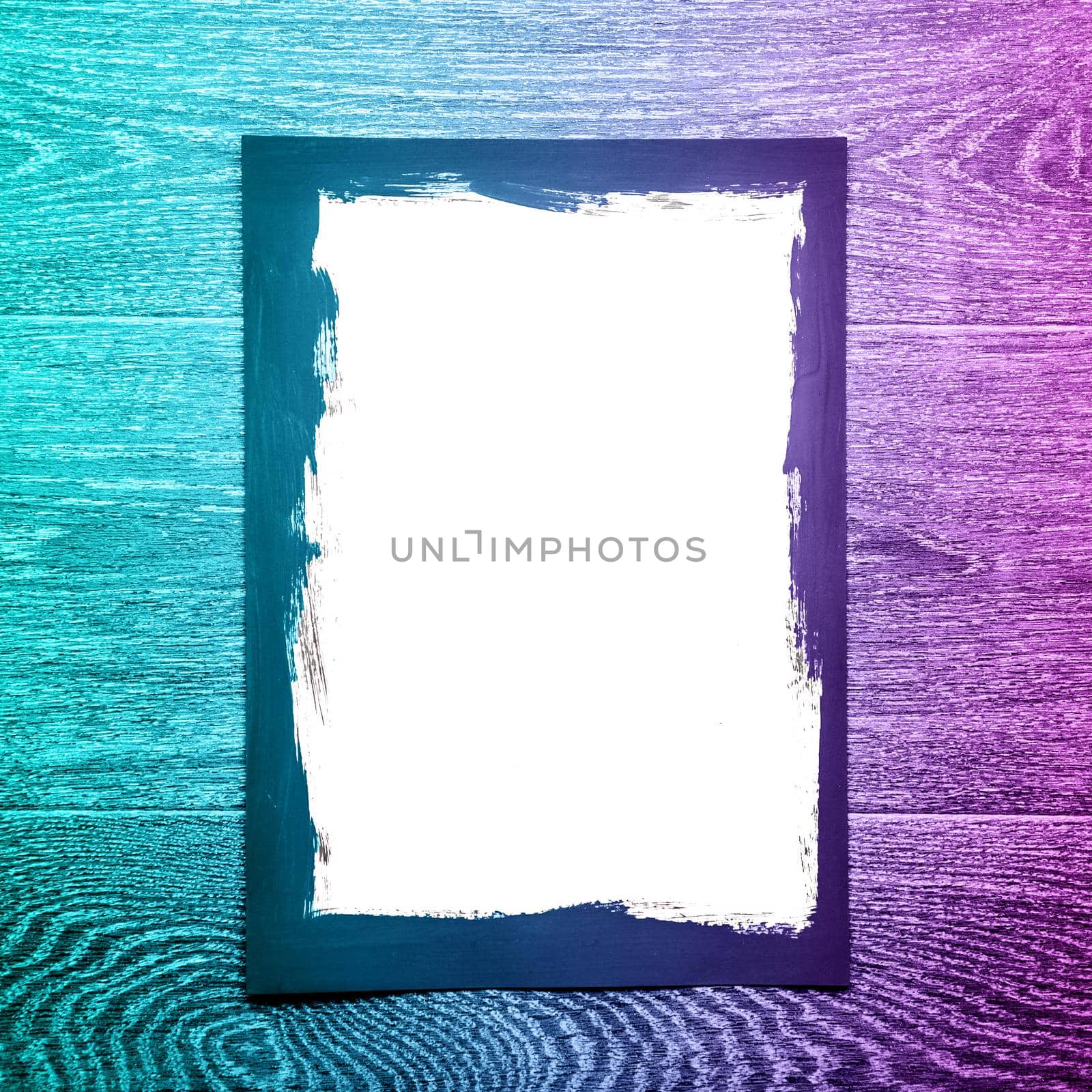 Black painted frame on white paper on wooden background with neon light - image