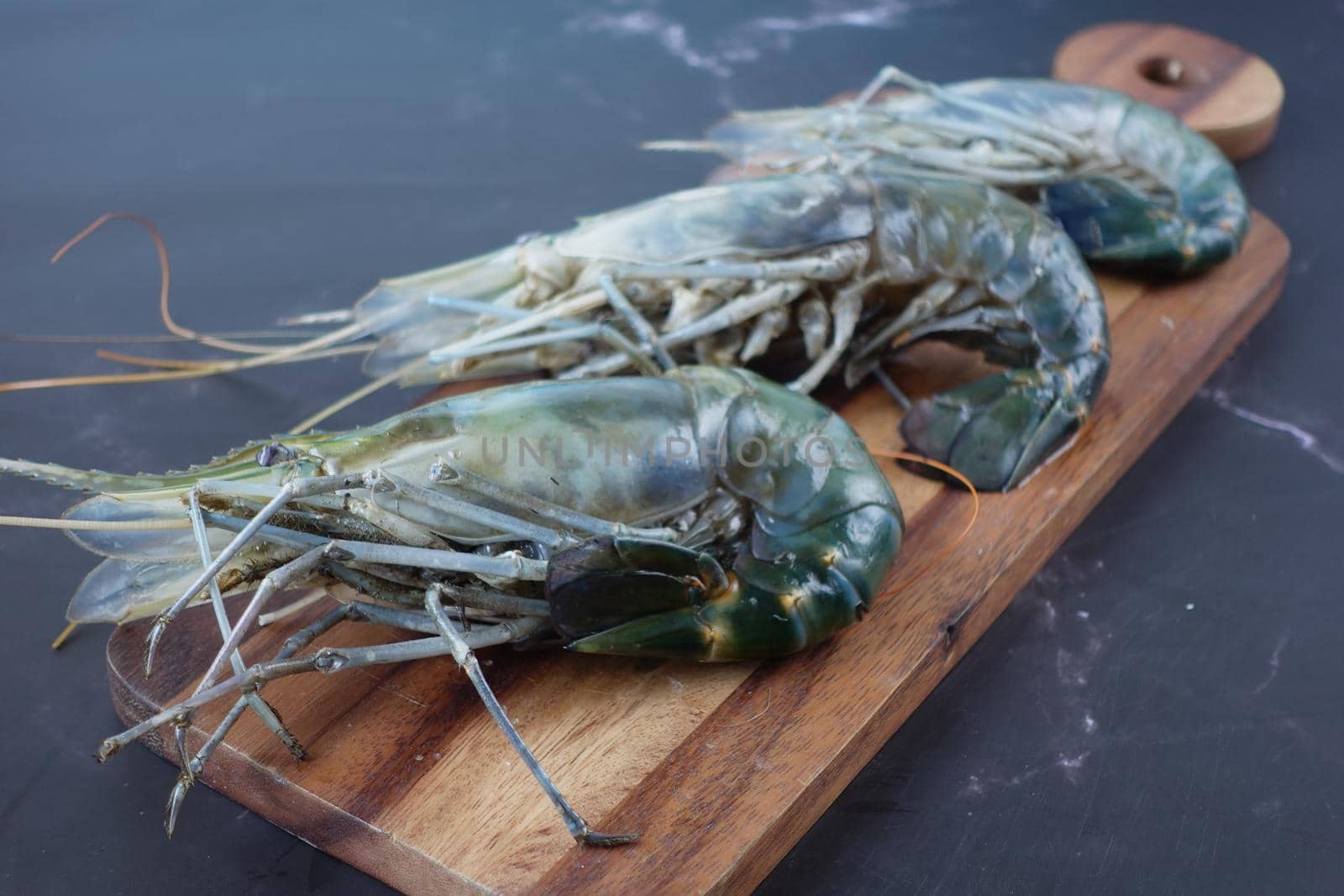 close up of king prawn on a chopping board on table..