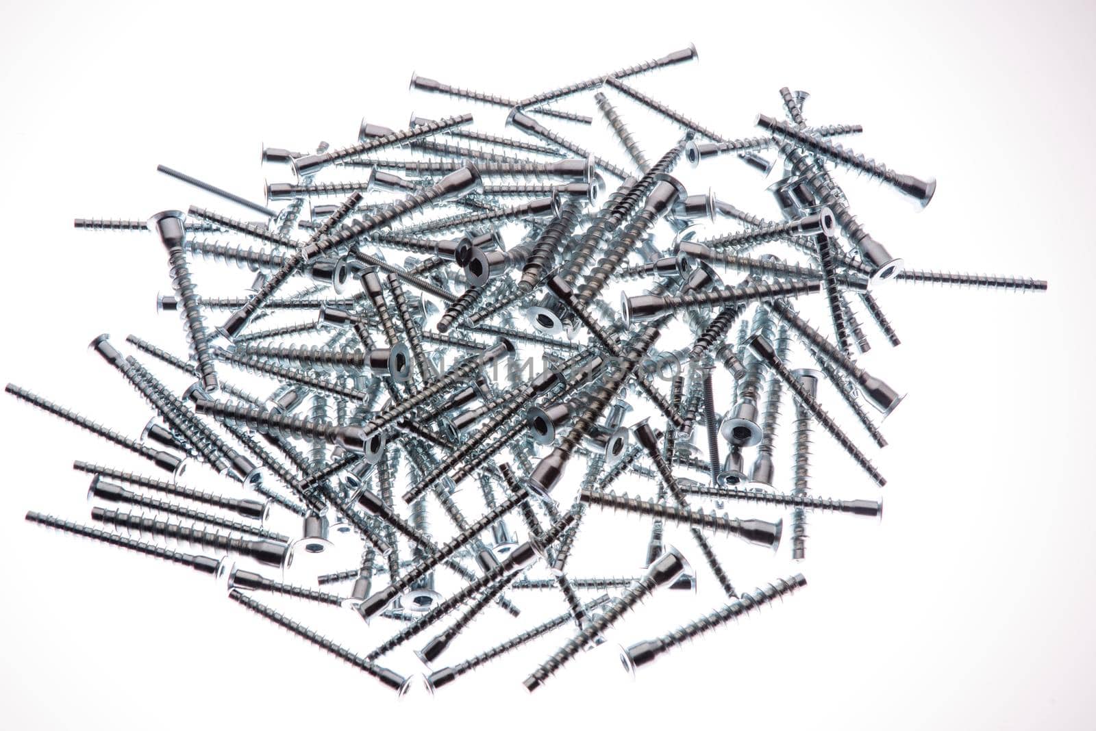 Mound of furniture screws top view on white background- image