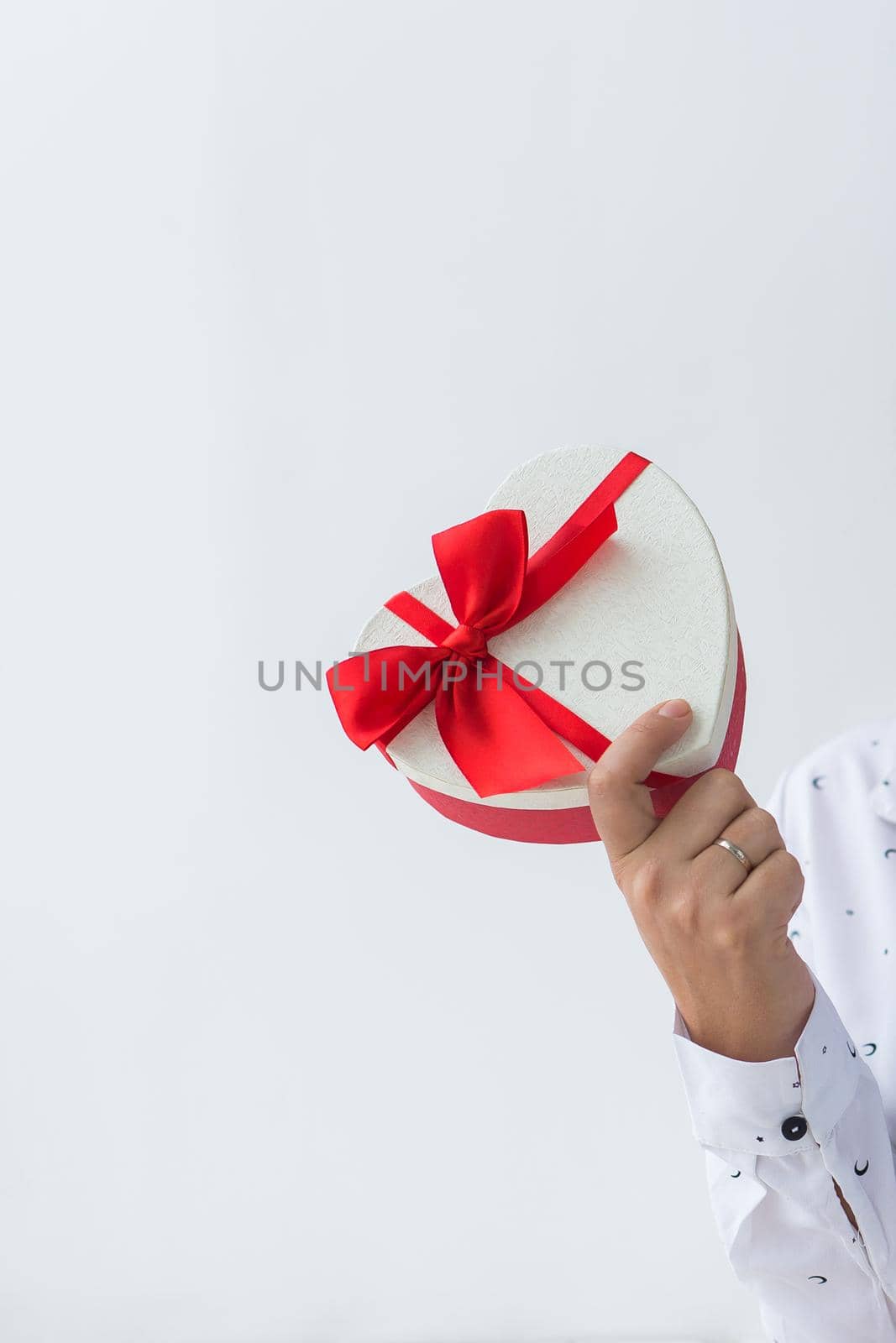 Female hands holding heart gift box on white background.