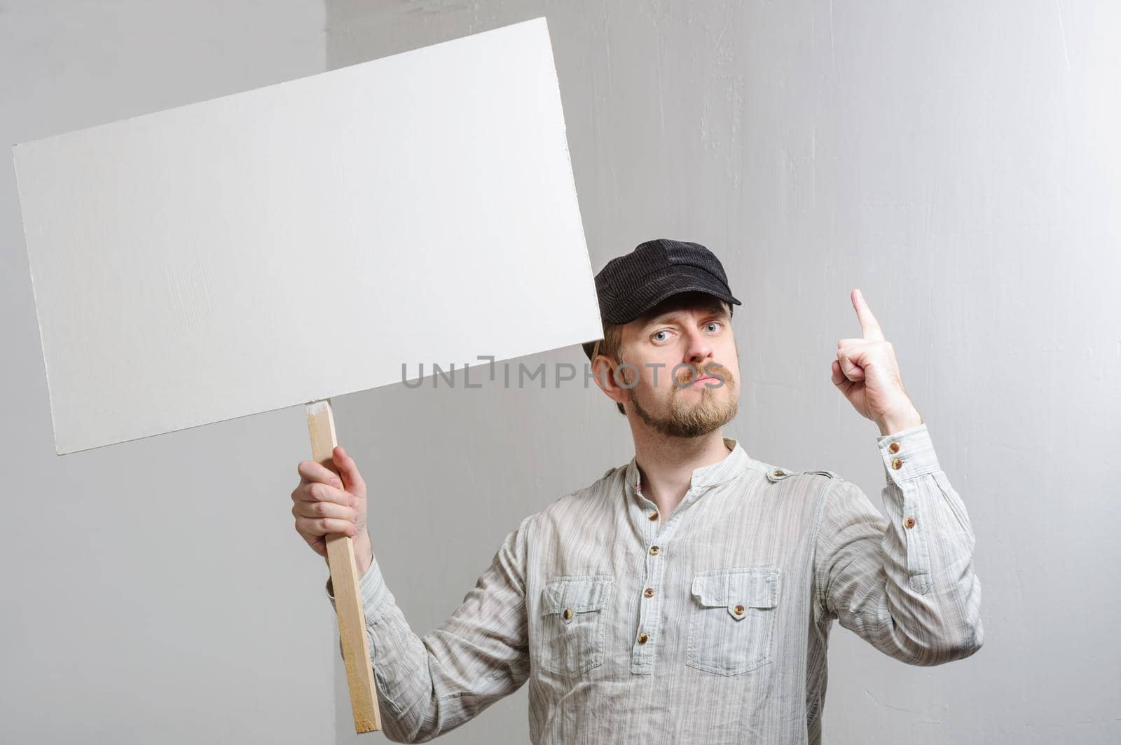 Work young man points finger on a blank banner - isolated on white.