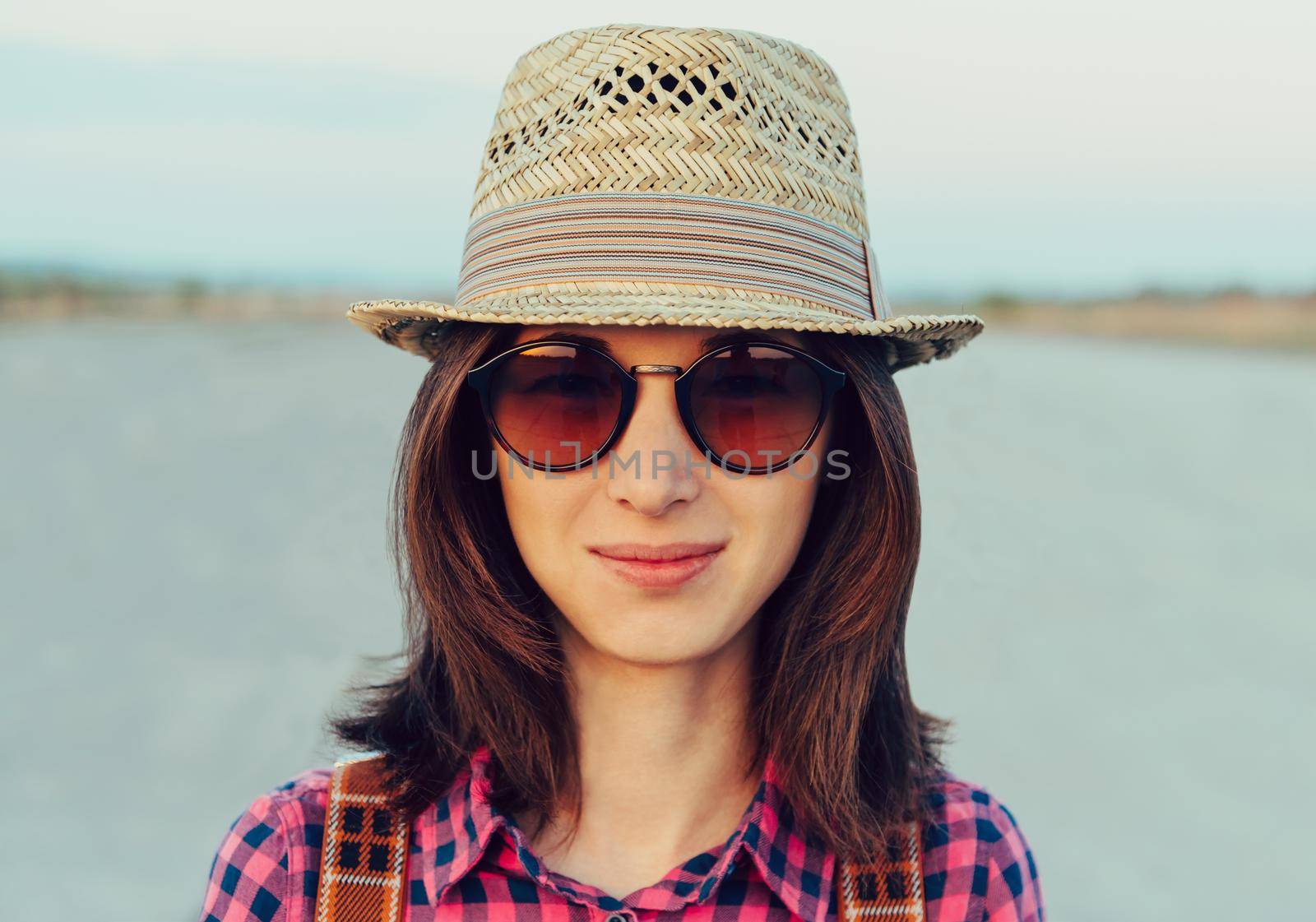 Portrait of smiling hipster girl in hat and sunglasses outdoor