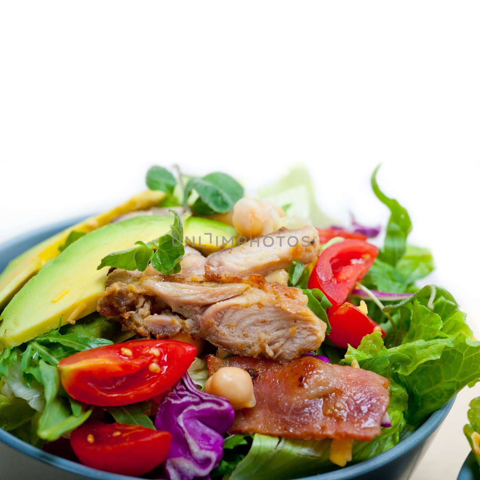 fresh and healthy Chicken Avocado salad over rustic wood table