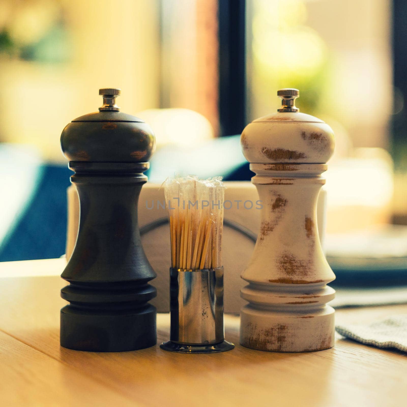 Vintage salt shaker and pepperbox on a table and toothpicks on a table in a cafe - image toned